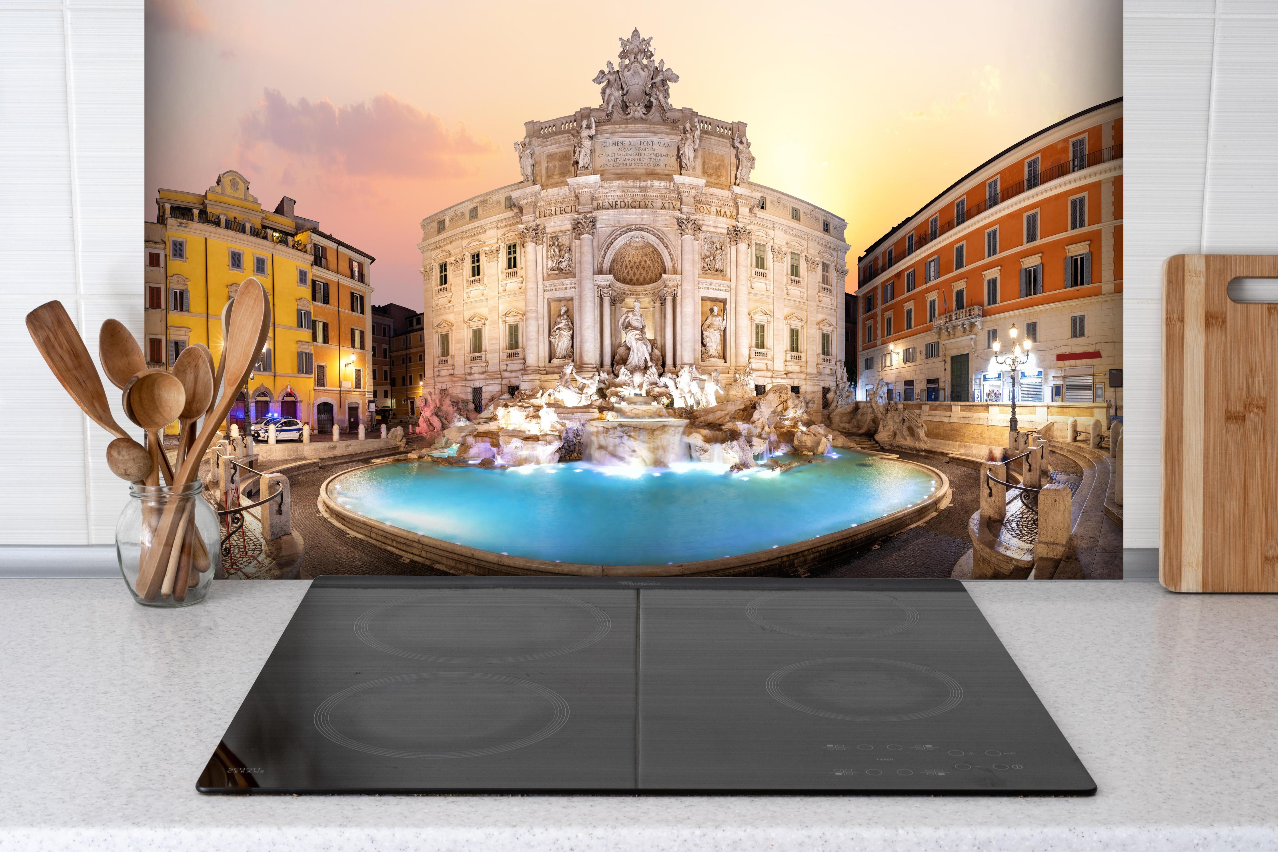 Spritzschutz - Trevi-Brunnen bei Sonnenaufgang hinter einem Cerankochfeld zwischen Holz-Kochutensilien