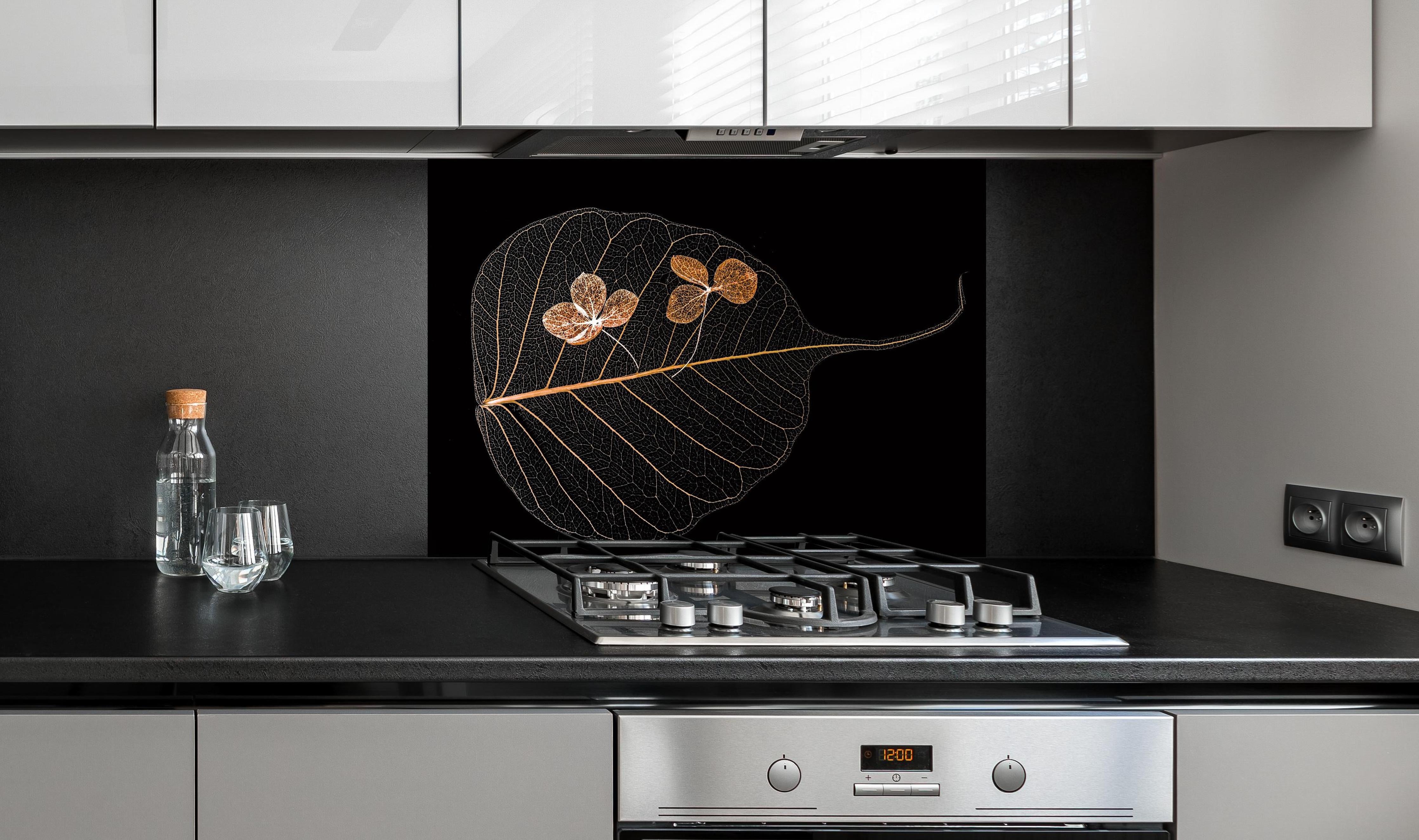 Spritzschutz - Trockene Blume im Detail hinter einem Cerankochfeld zwischen Holz-Kochutensilien