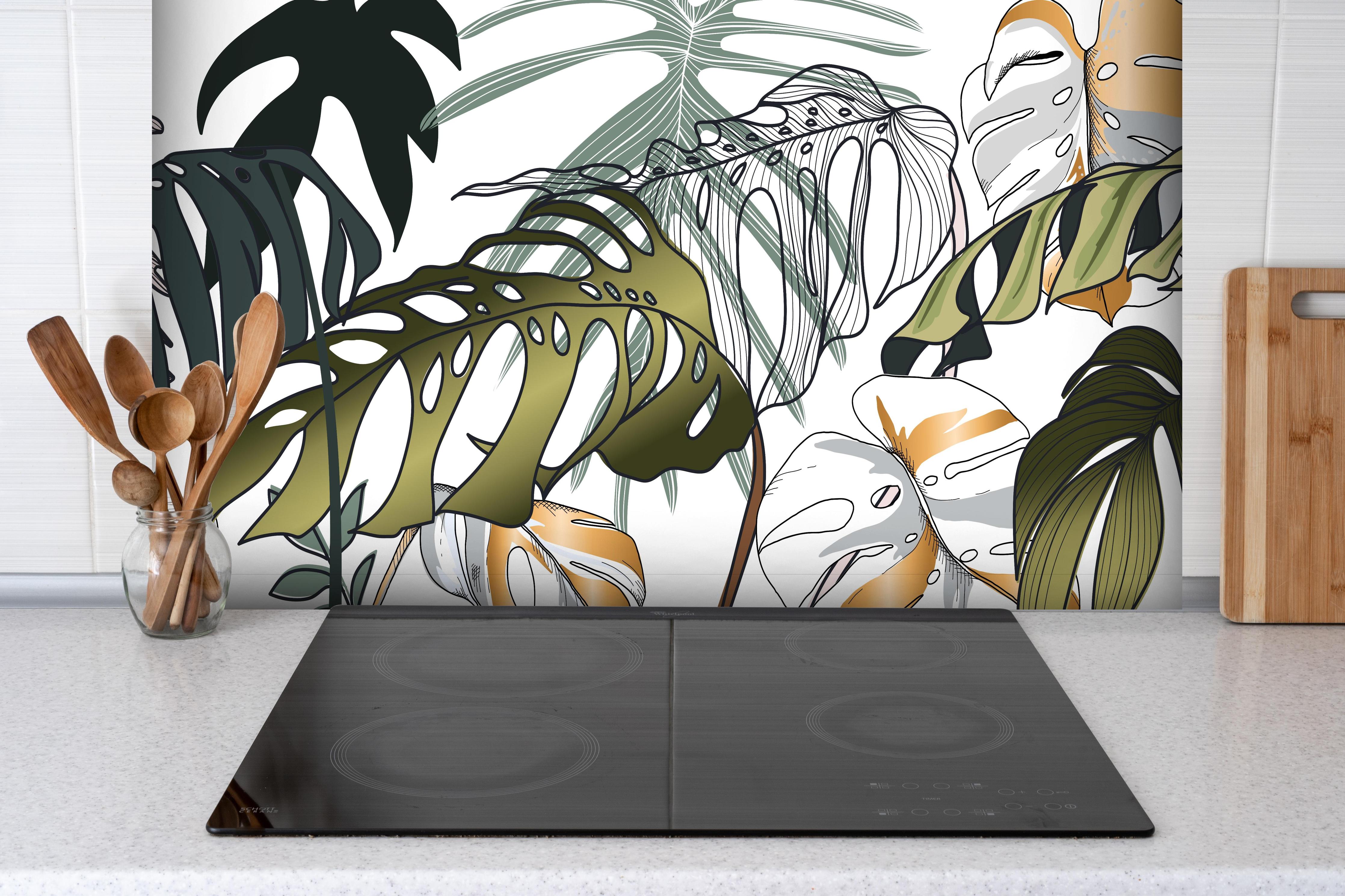 Spritzschutz - Tropische Blätter hinter einem Cerankochfeld zwischen Holz-Kochutensilien