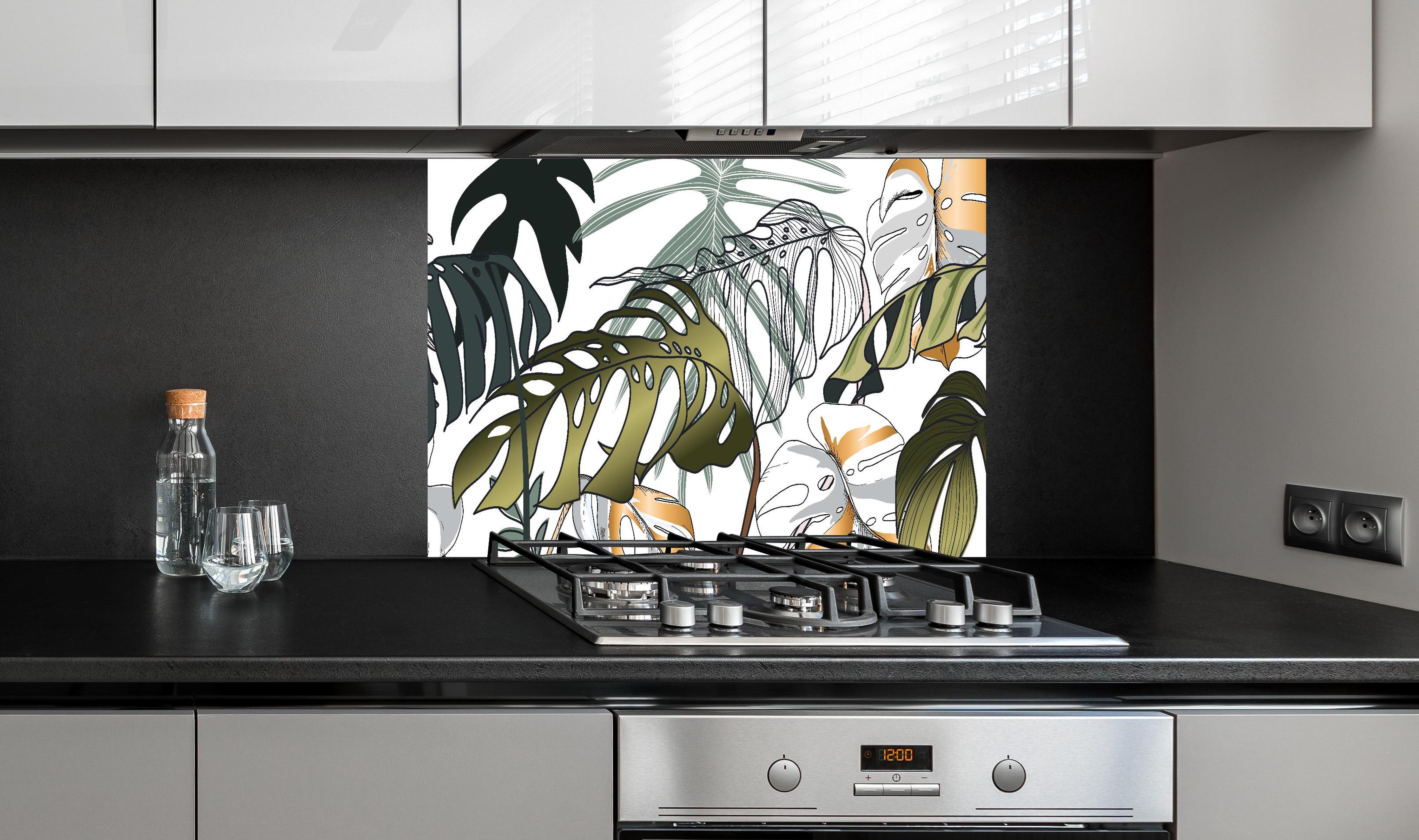 Spritzschutz - Tropische Blätter hinter einem Cerankochfeld zwischen Holz-Kochutensilien