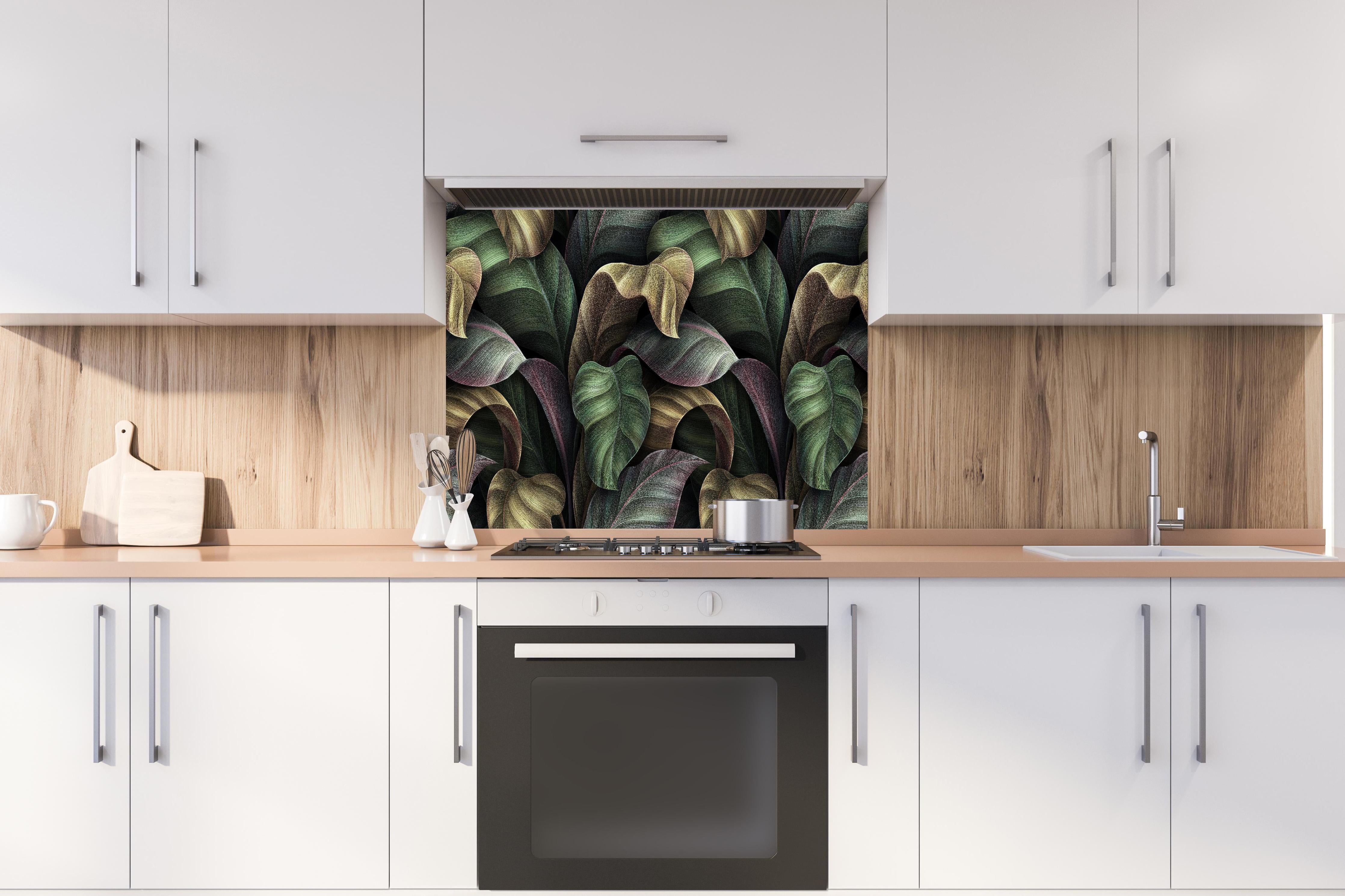 Spritzschutz - Tropische Blätter in Gold - Malerei hinter einem Cerankochfeld zwischen Holz-Kochutensilien