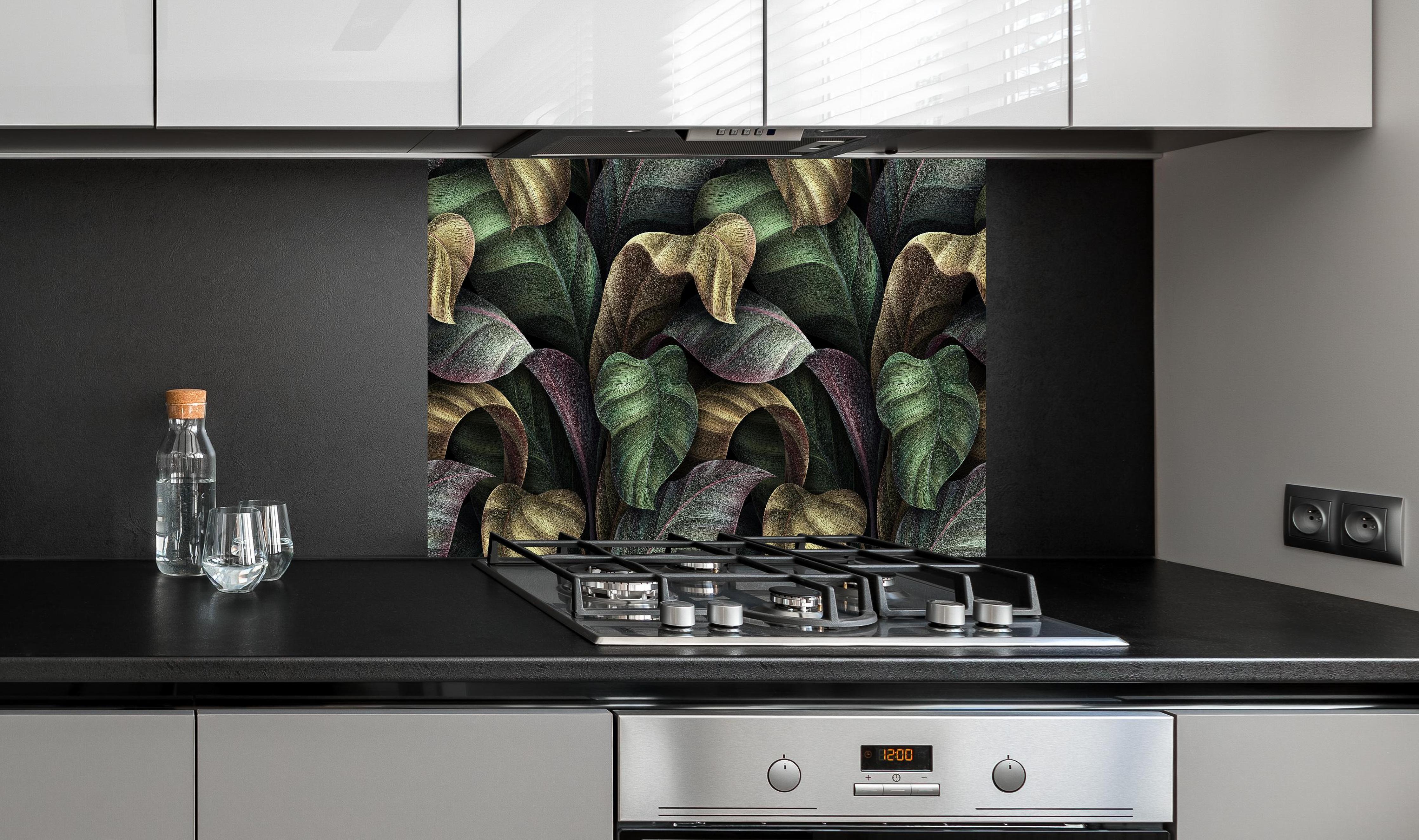 Spritzschutz - Tropische Blätter in Gold - Malerei hinter einem Cerankochfeld zwischen Holz-Kochutensilien