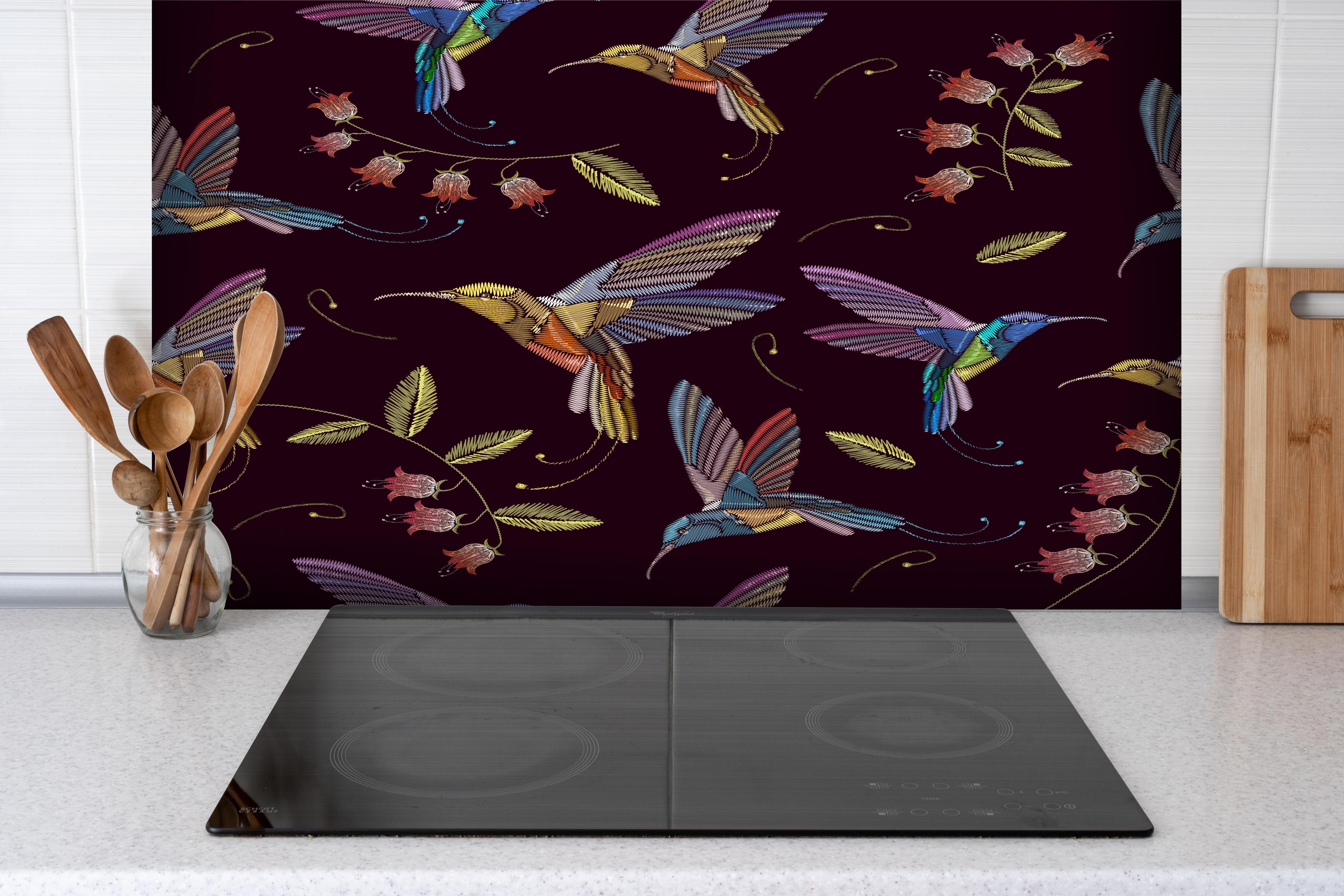 Spritzschutz - Tropische Kolibri-Blumen-Stickerei hinter einem Cerankochfeld zwischen Holz-Kochutensilien