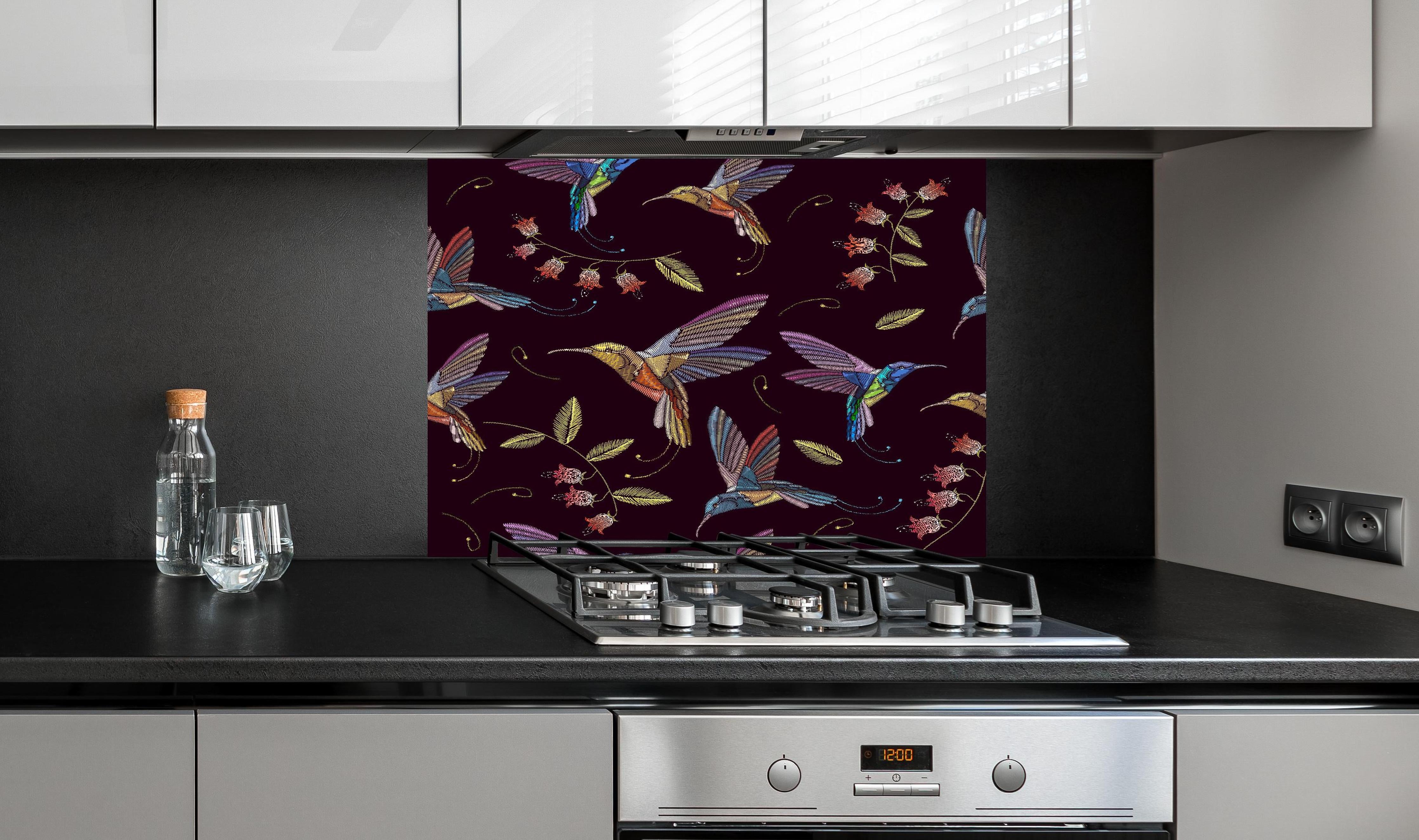 Spritzschutz - Tropische Kolibri-Blumen-Stickerei hinter einem Cerankochfeld zwischen Holz-Kochutensilien