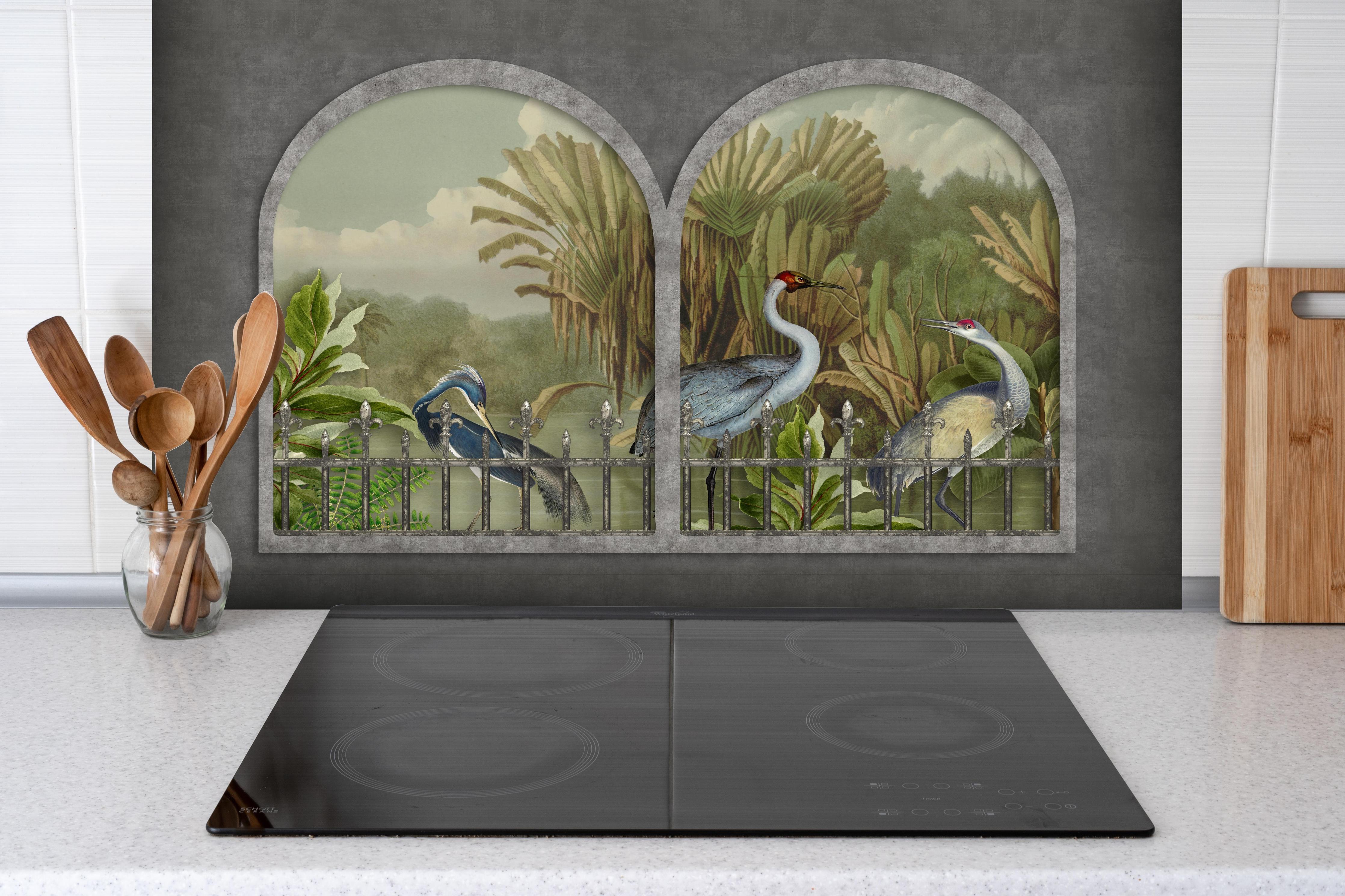 Spritzschutz - Tropischer Dschungel mit Kranichen Motiv hinter einem Cerankochfeld zwischen Holz-Kochutensilien