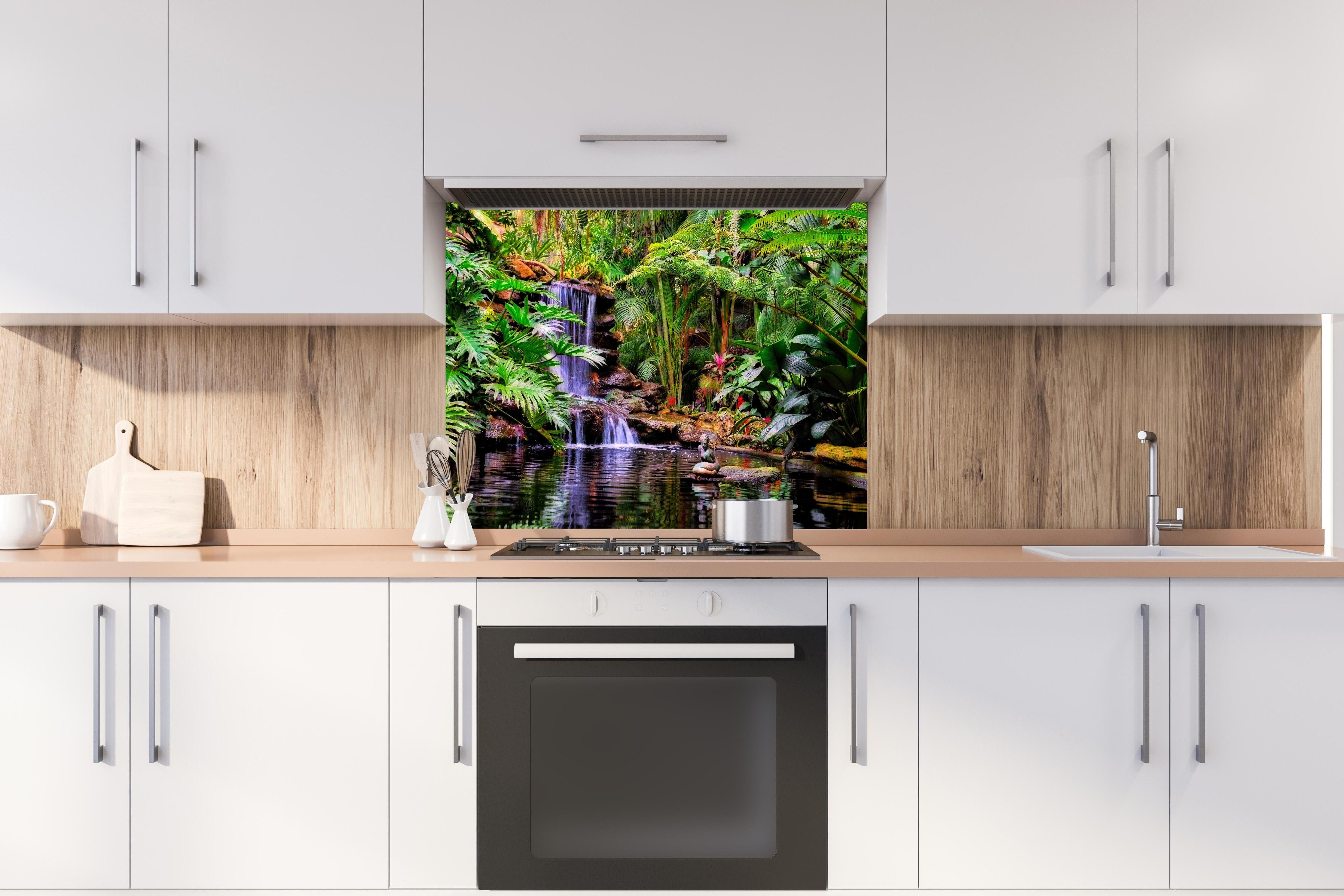 Spritzschutz - Tropischer Wasserfall hinter einem Cerankochfeld zwischen Holz-Kochutensilien