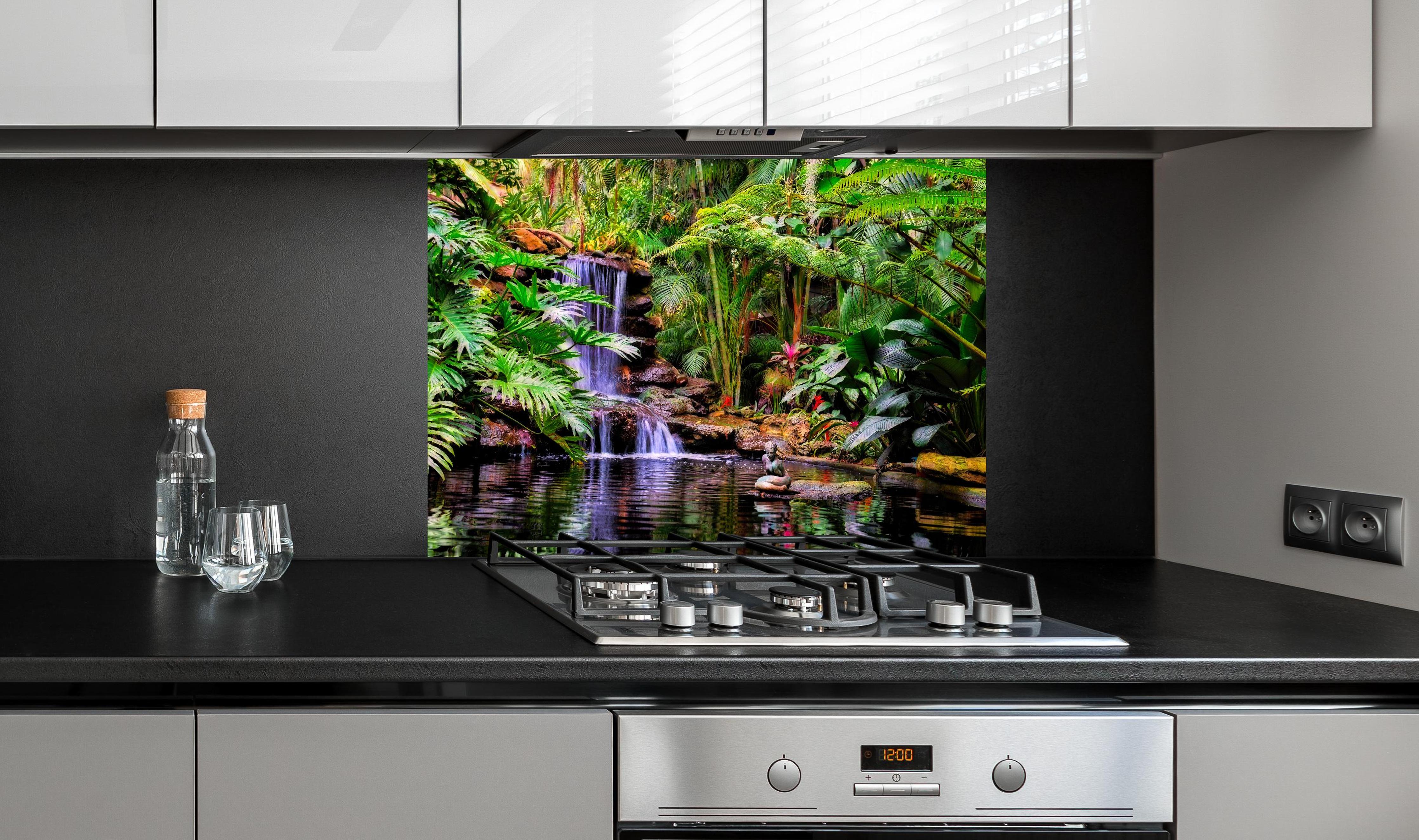 Spritzschutz - Tropischer Wasserfall hinter einem Cerankochfeld zwischen Holz-Kochutensilien