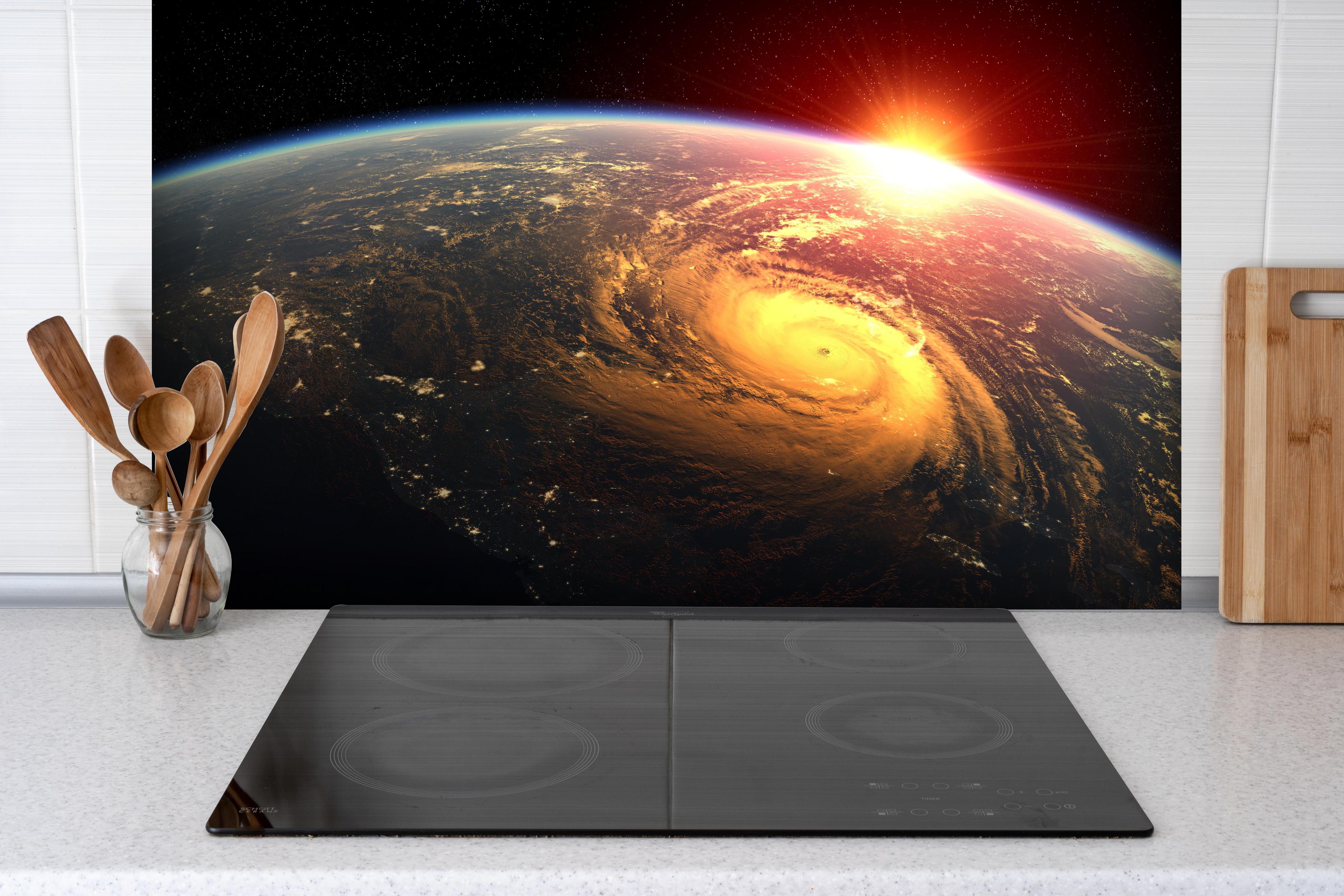 Spritzschutz - Tropischer Wirbelsturm aus dem Weltraum hinter einem Cerankochfeld zwischen Holz-Kochutensilien