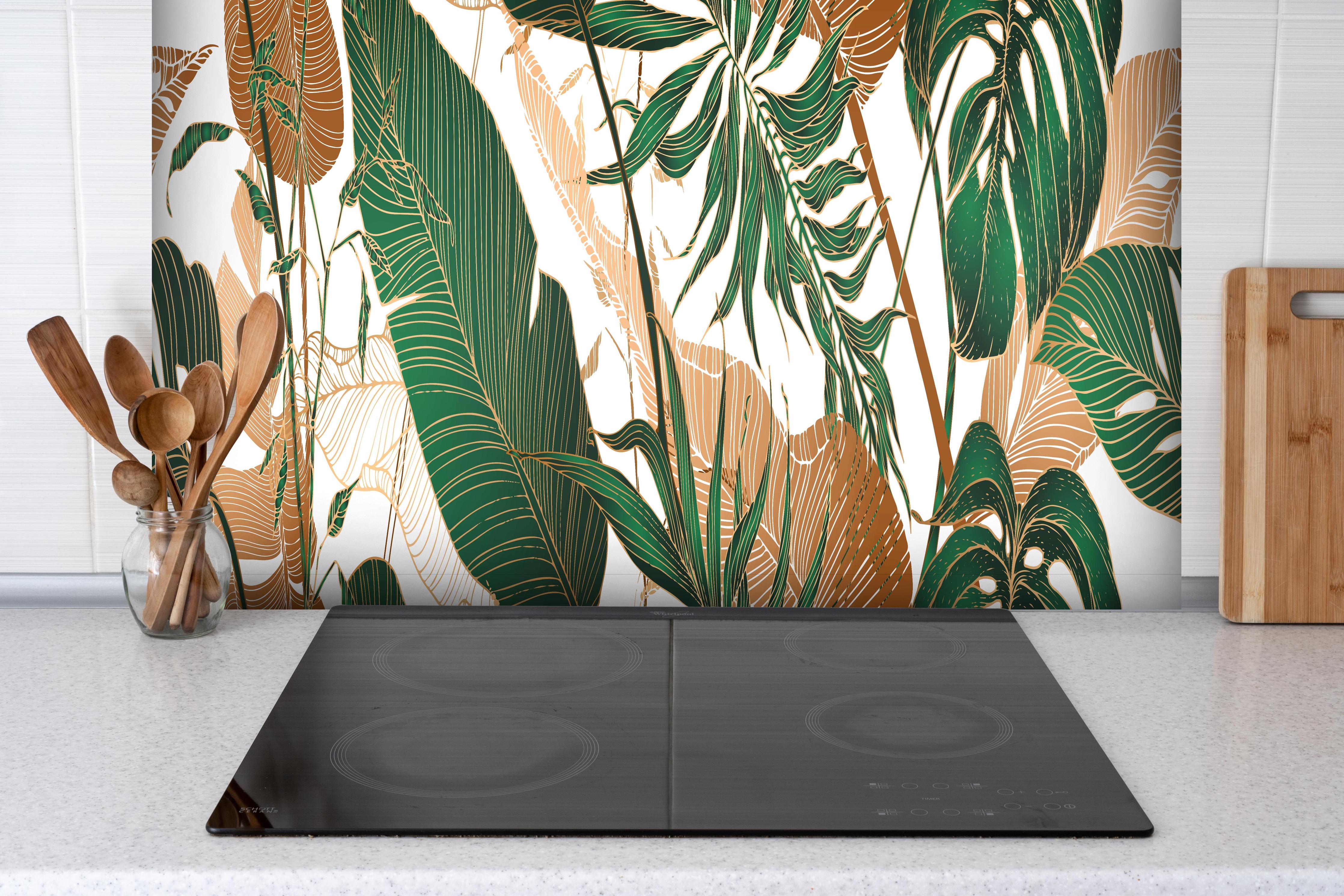 Spritzschutz - Tropisches Blattmuster Grün-Beige hinter einem Cerankochfeld zwischen Holz-Kochutensilien
