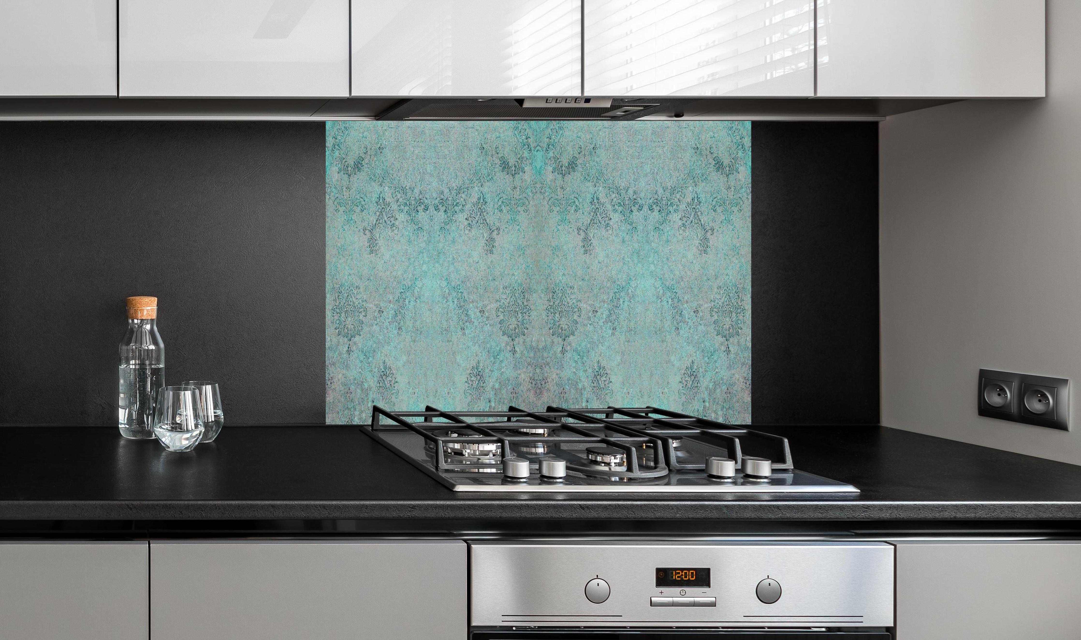 Spritzschutz - Türkis-Graues Design im Vintage-Look hinter einem Cerankochfeld zwischen Holz-Kochutensilien