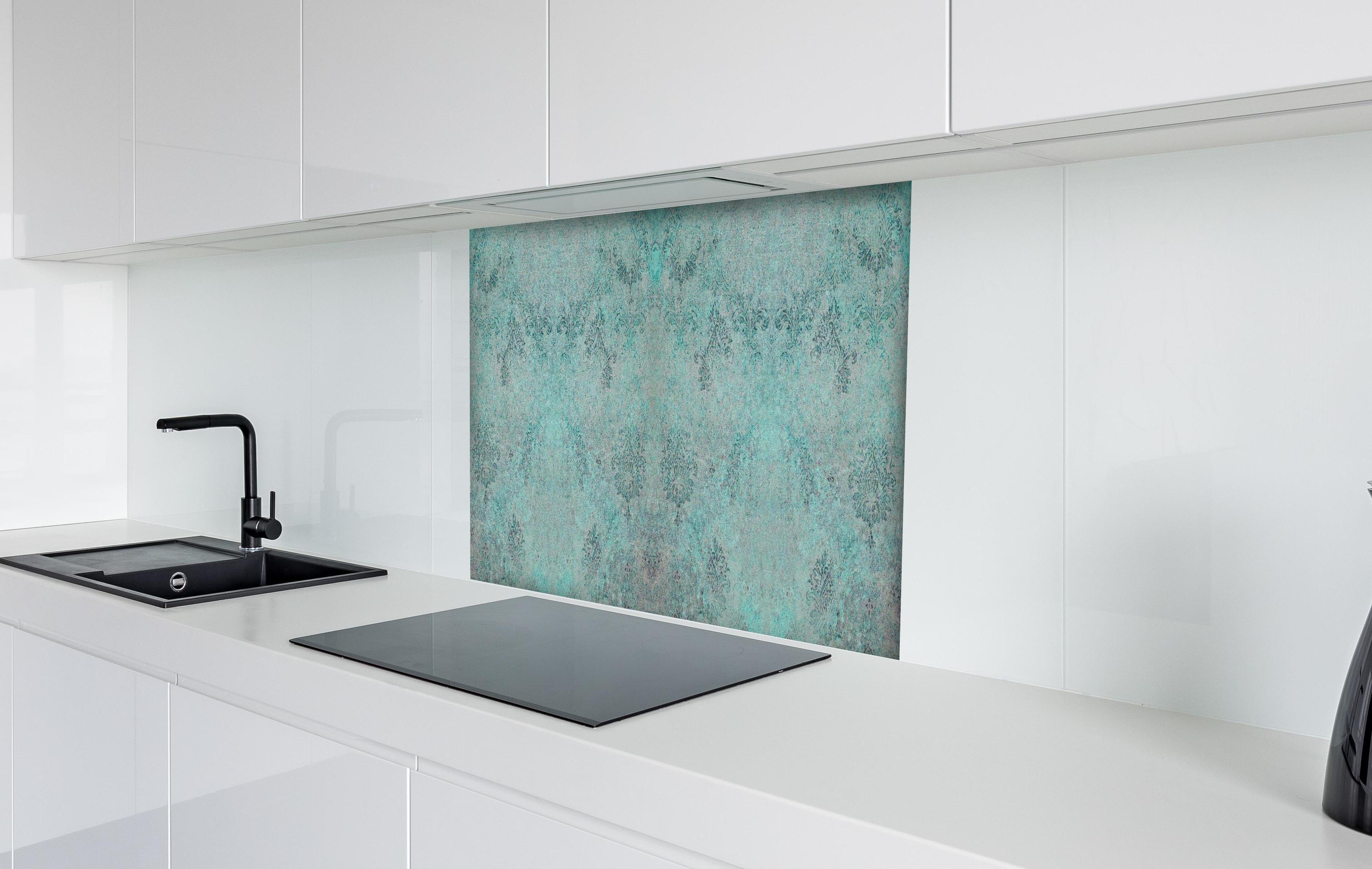 Spritzschutz - Türkis-Graues Design im Vintage-Look hinter einem Cerankochfeld zwischen Holz-Kochutensilien