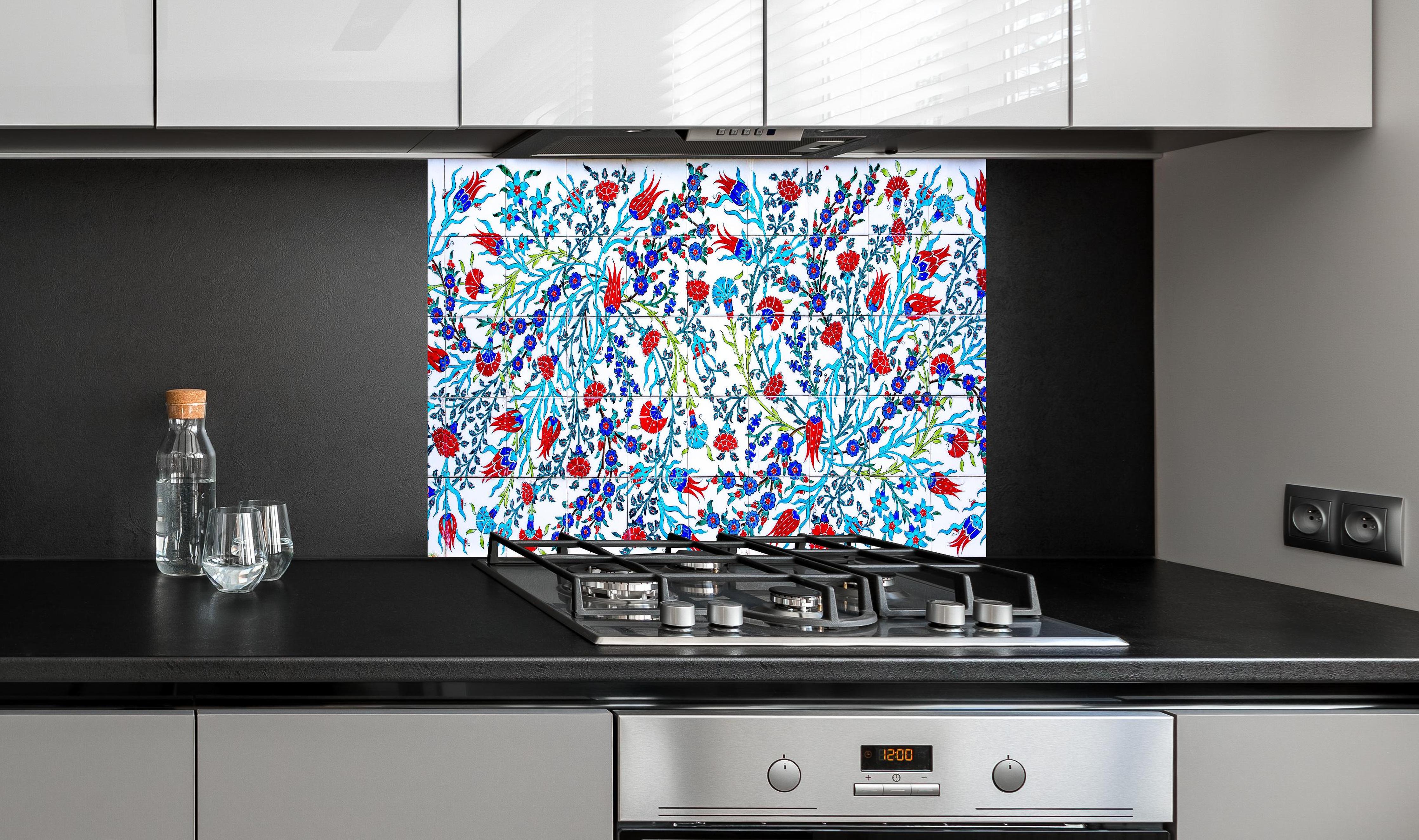Spritzschutz - Türkische Wandfliese mit floralem Muster hinter einem Cerankochfeld zwischen Holz-Kochutensilien