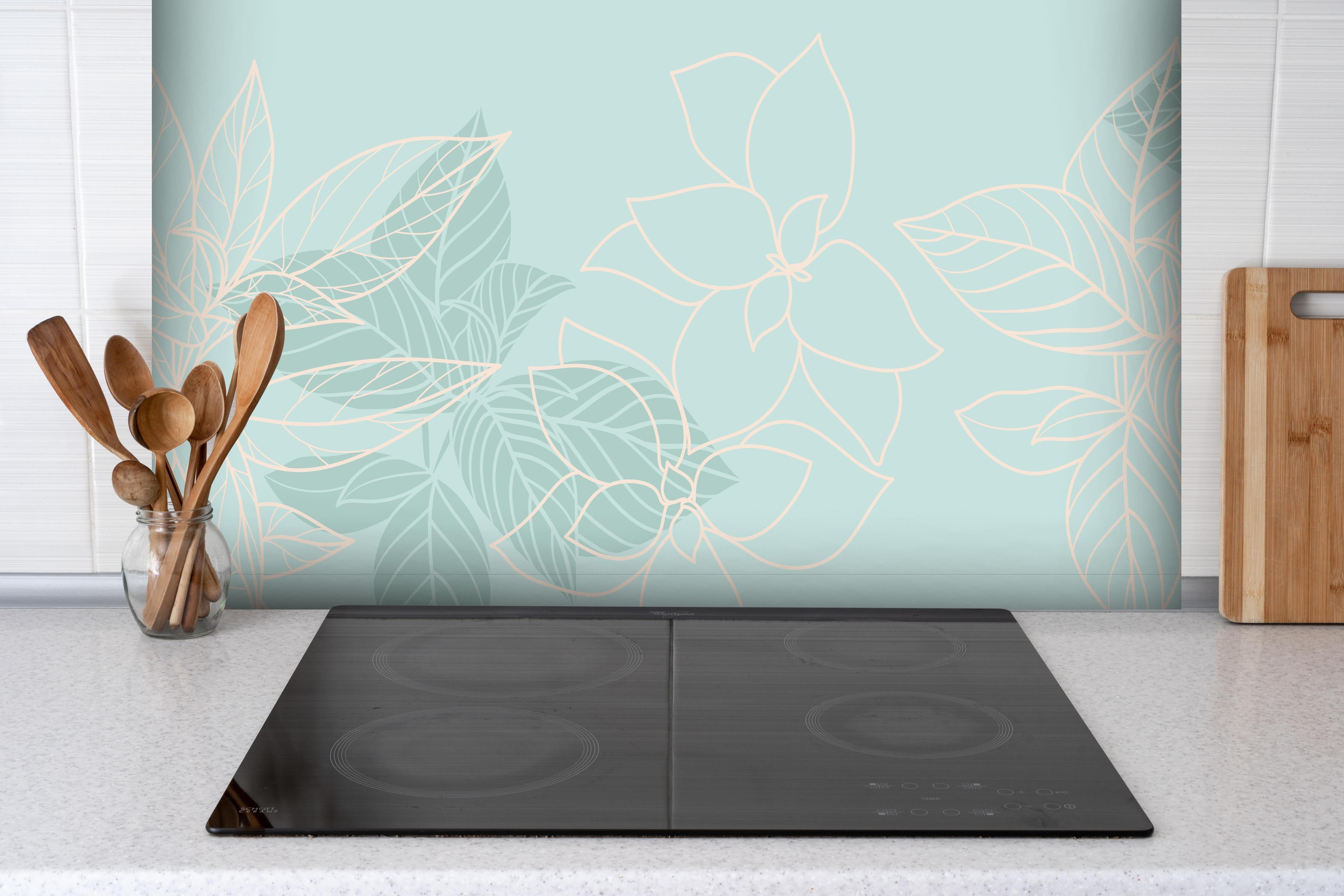 Spritzschutz - Türkise Pflanzen hinter einem Cerankochfeld zwischen Holz-Kochutensilien