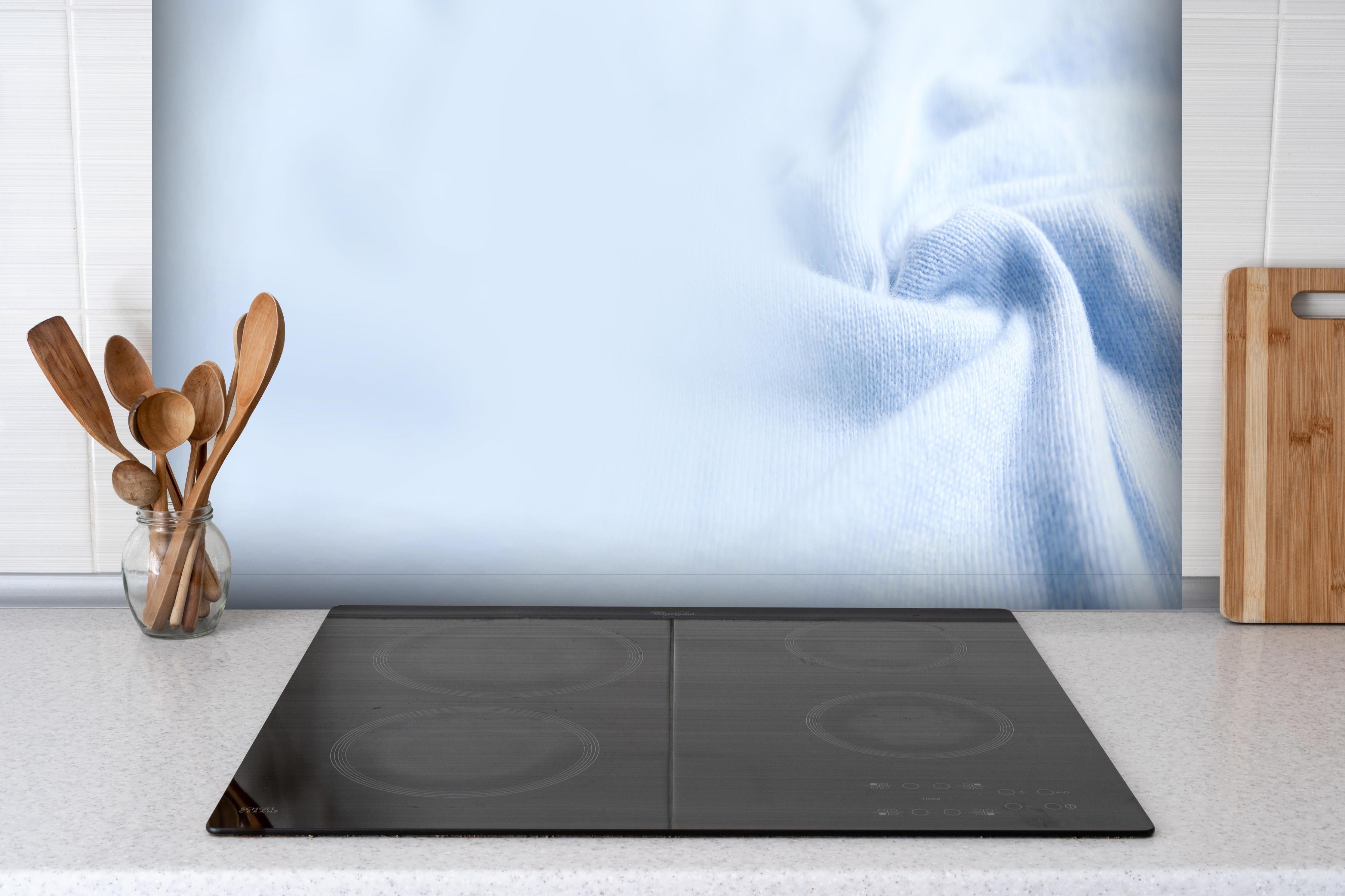Spritzschutz - Türkiser Kaschmirstoff hinter einem Cerankochfeld zwischen Holz-Kochutensilien