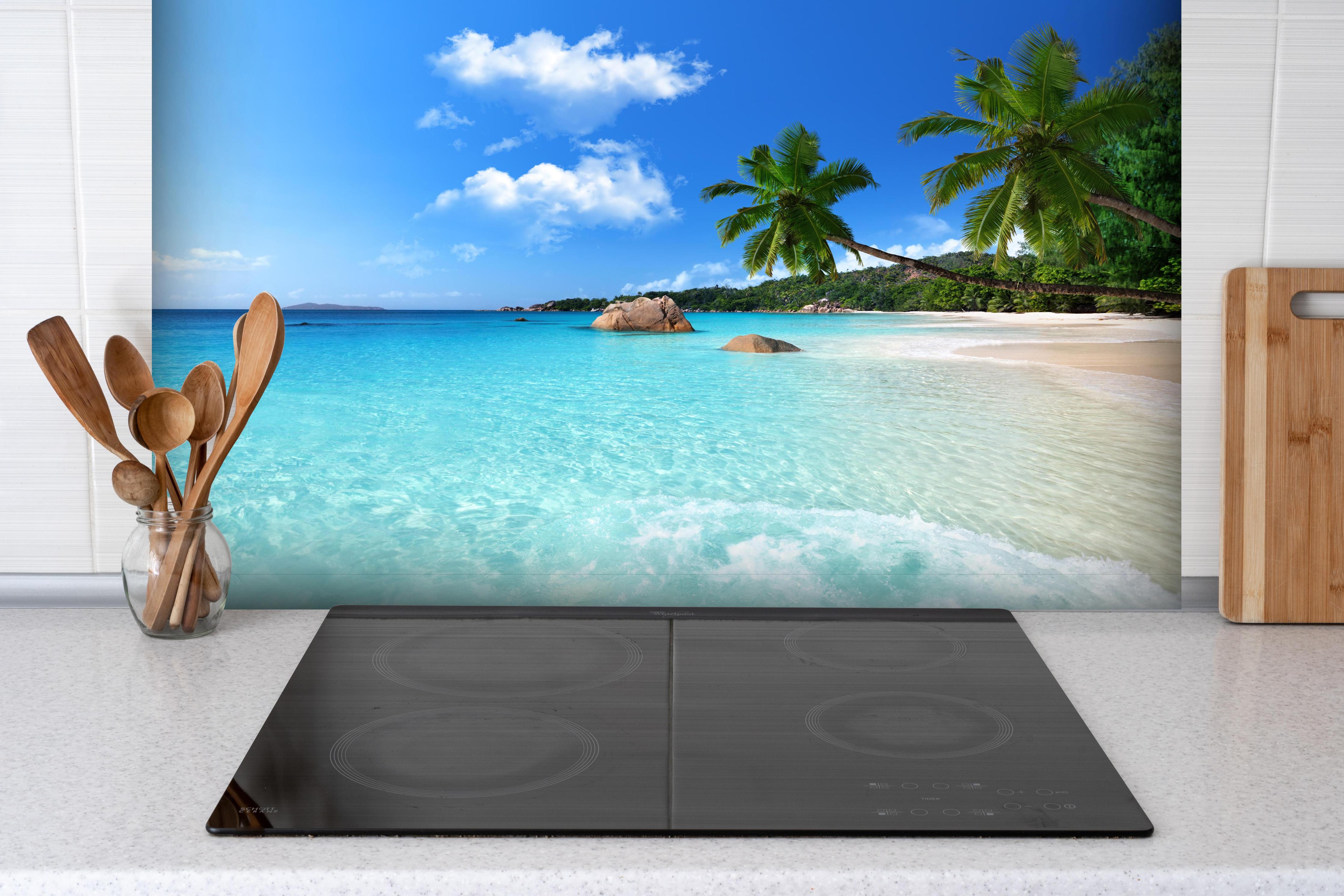 Spritzschutz - Türkises Meer und blauer Himmel Seychellen hinter einem Cerankochfeld zwischen Holz-Kochutensilien