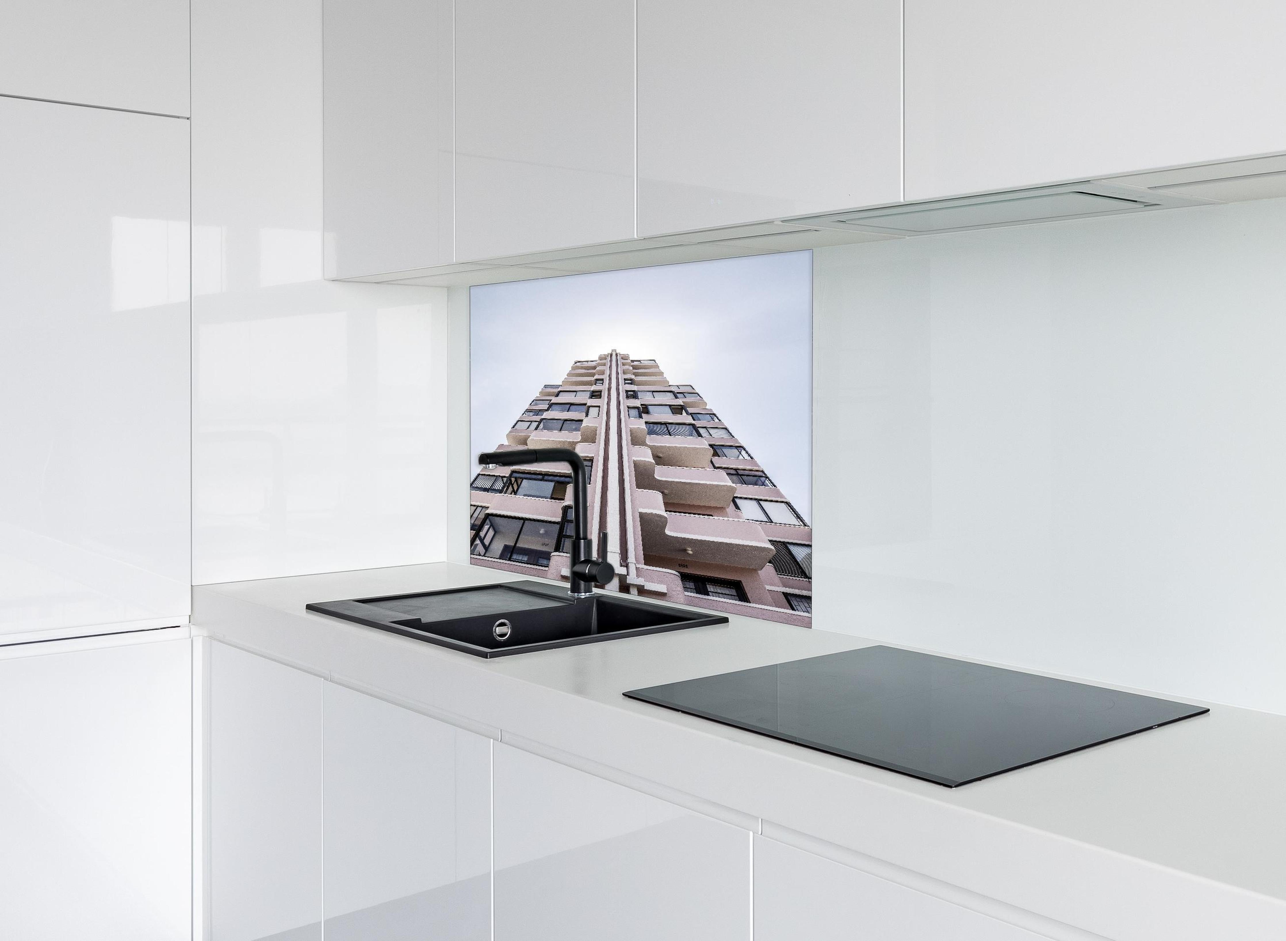 Spritzschutz - Urbanes Hochhaus mit grau-beigen Akzenten hinter einem Cerankochfeld zwischen Holz-Kochutensilien
