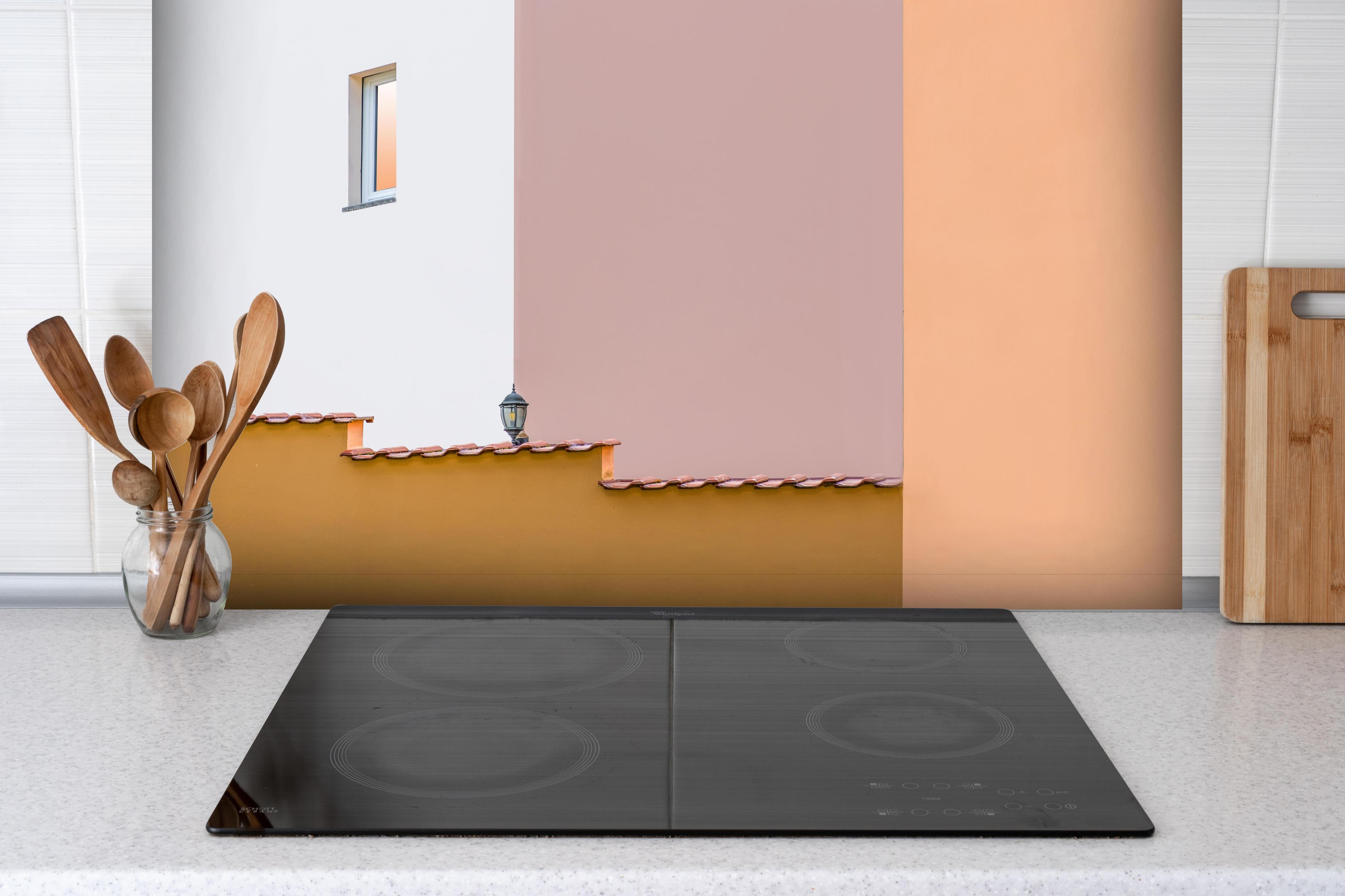 Spritzschutz - Urbanes Pastell-Dämmerlicht mit Straßenlaterne hinter einem Cerankochfeld zwischen Holz-Kochutensilien