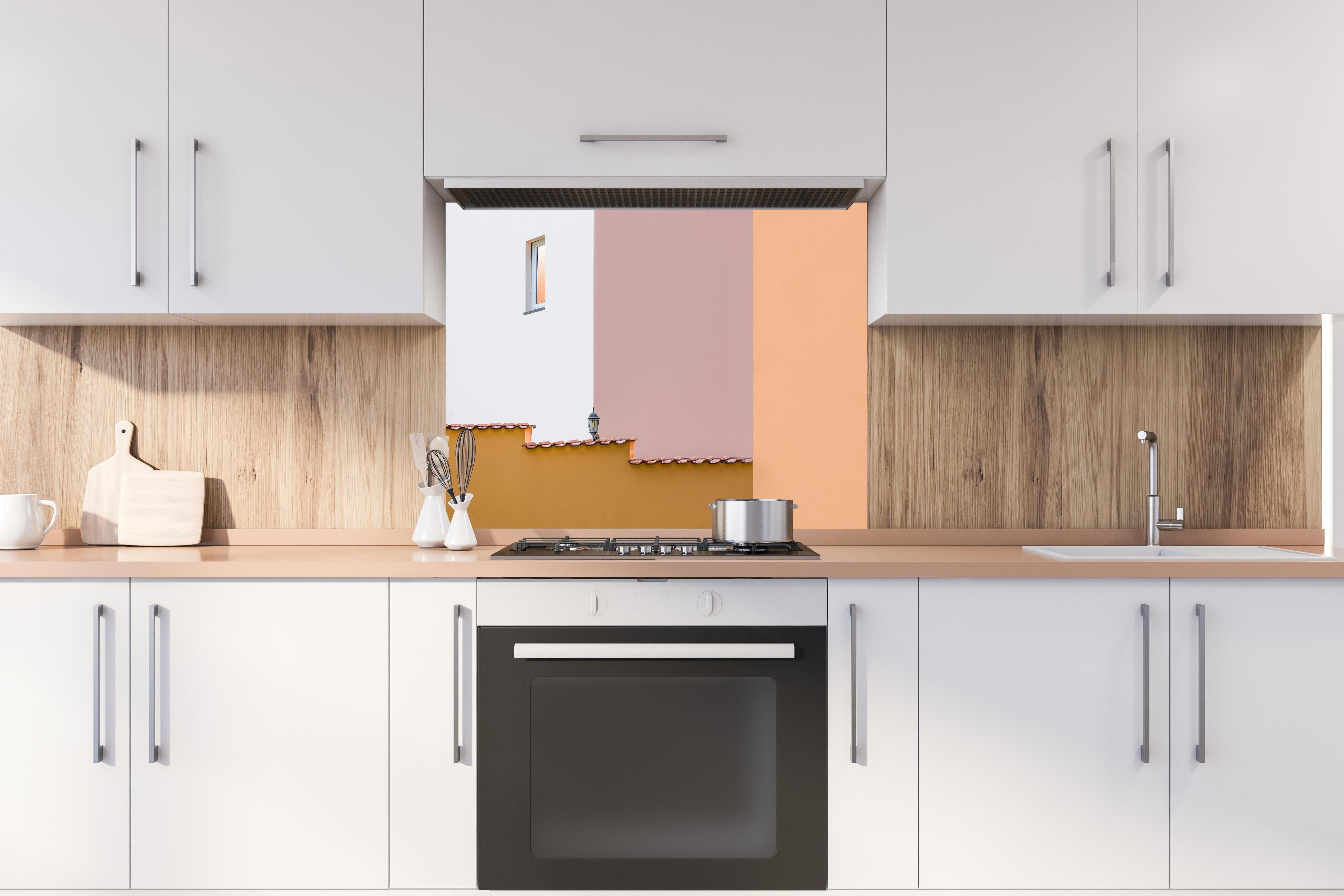 Spritzschutz - Urbanes Pastell-Dämmerlicht mit Straßenlaterne hinter einem Cerankochfeld zwischen Holz-Kochutensilien