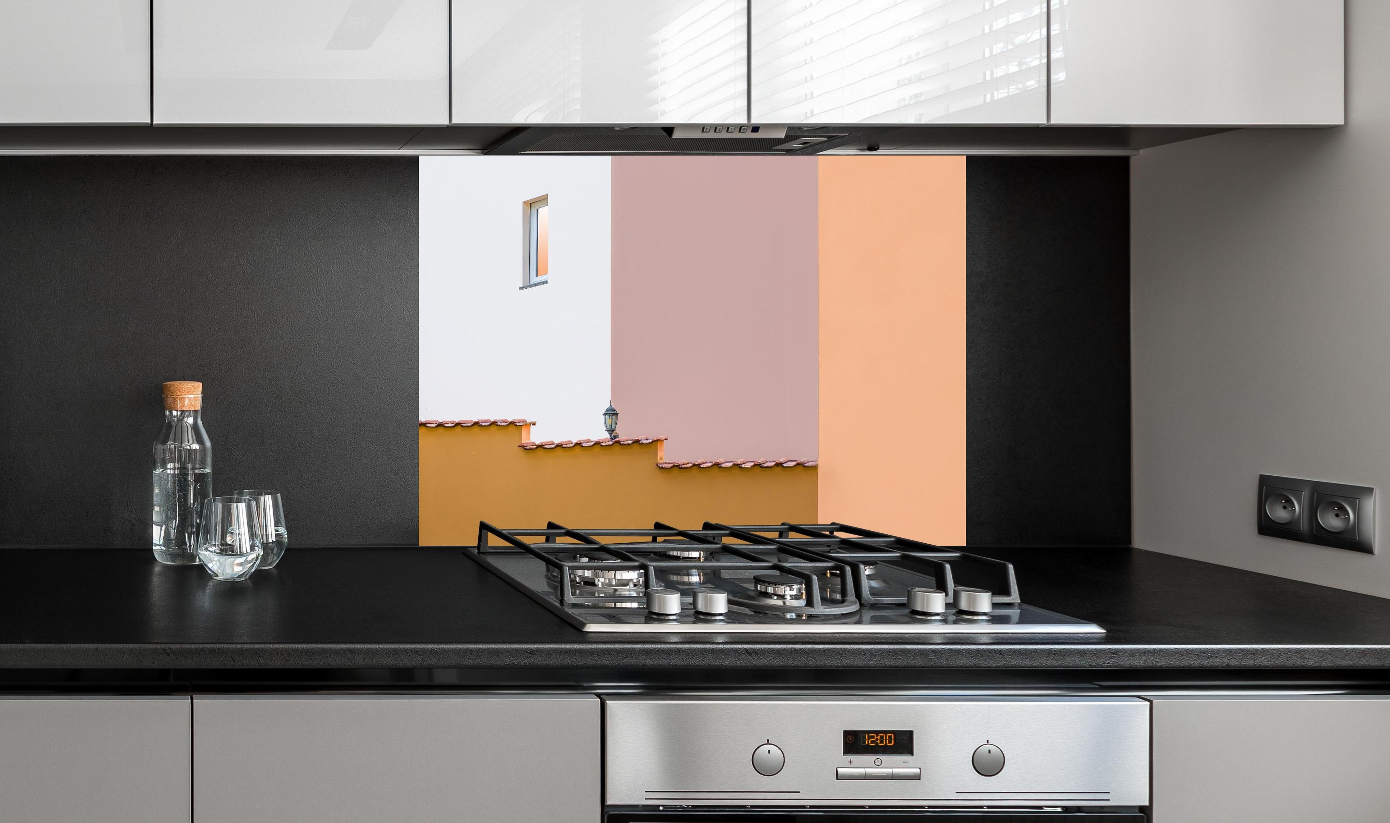 Spritzschutz - Urbanes Pastell-Dämmerlicht mit Straßenlaterne hinter einem Cerankochfeld zwischen Holz-Kochutensilien