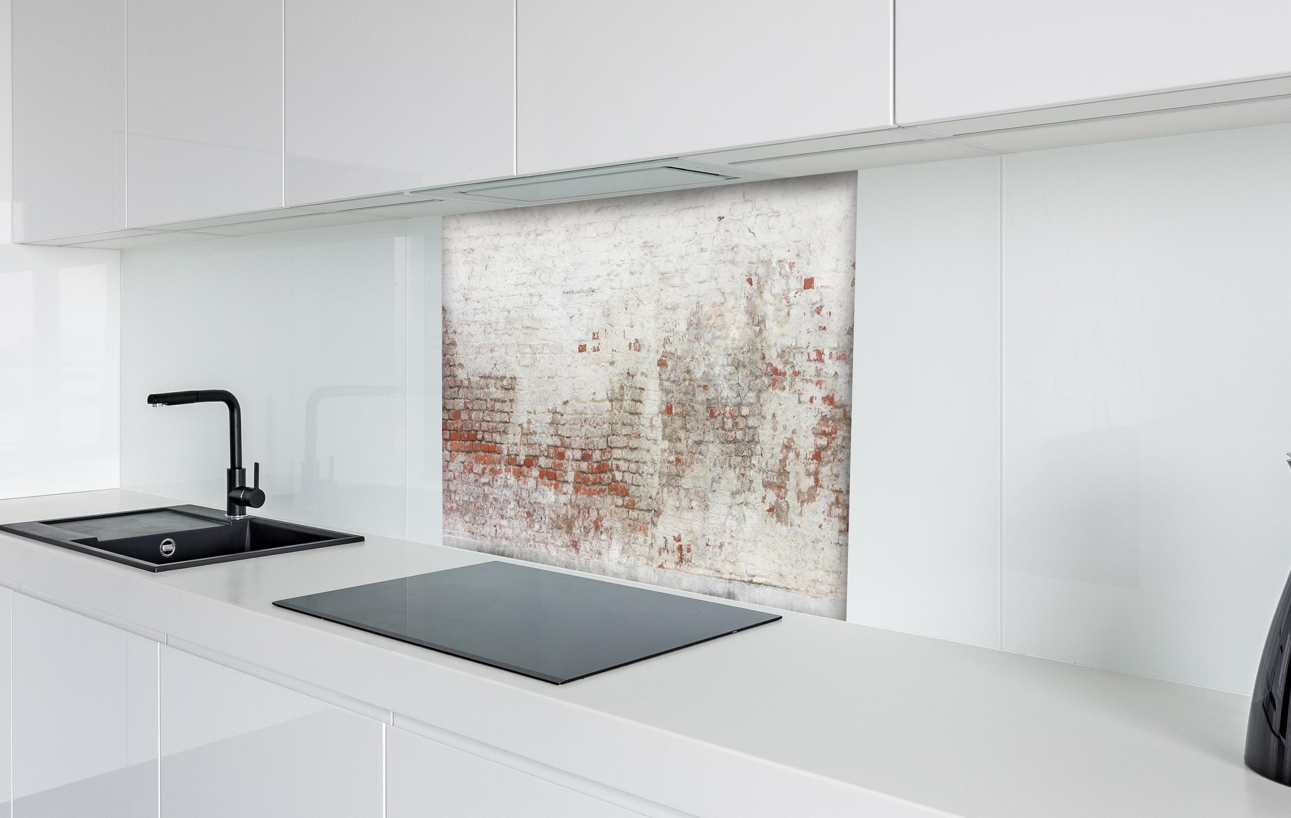 Spritzschutz - Veraltete Hauswand hinter einem Cerankochfeld zwischen Holz-Kochutensilien