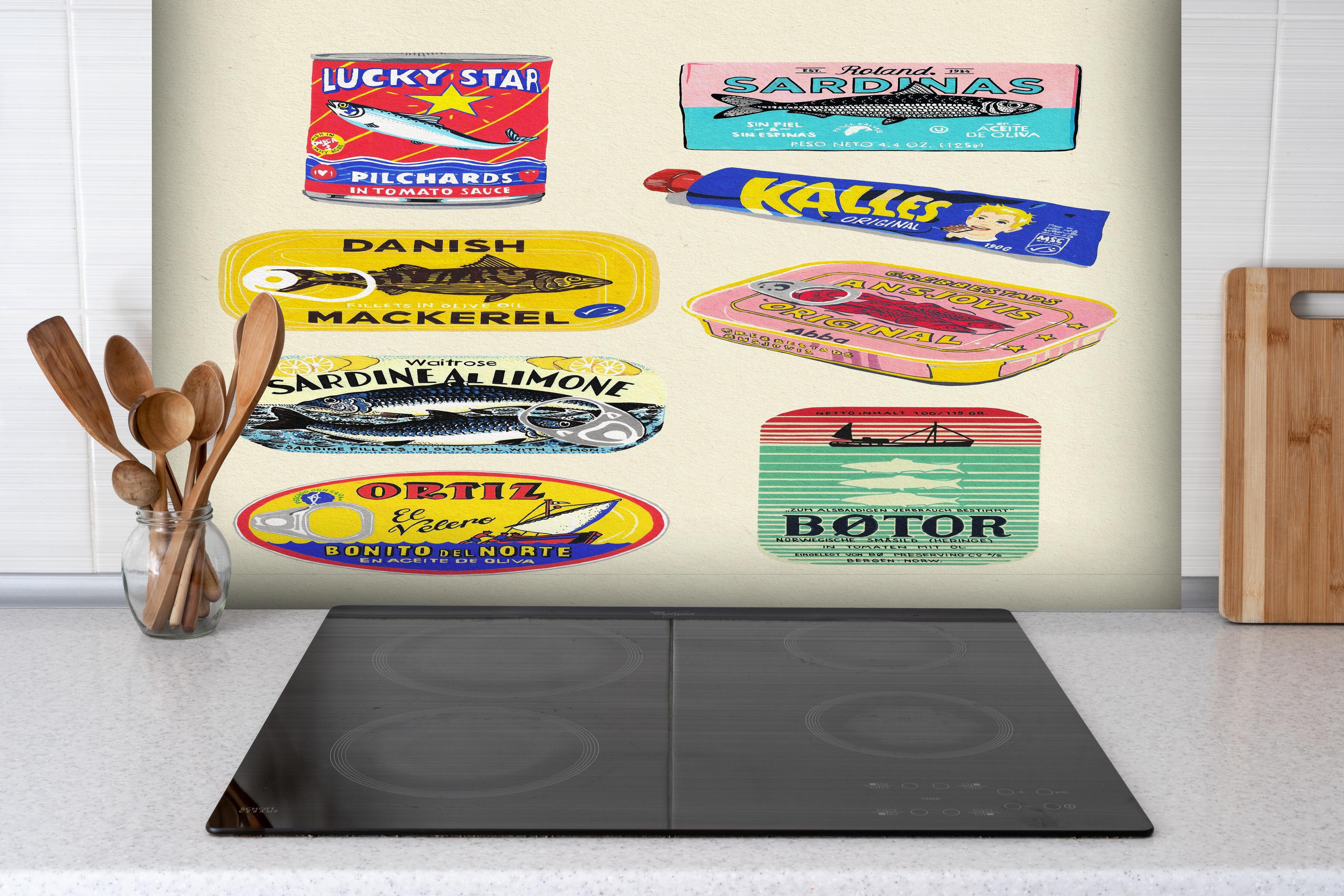 Spritzschutz - Verschiedenste Dosenfische hinter einem Cerankochfeld zwischen Holz-Kochutensilien