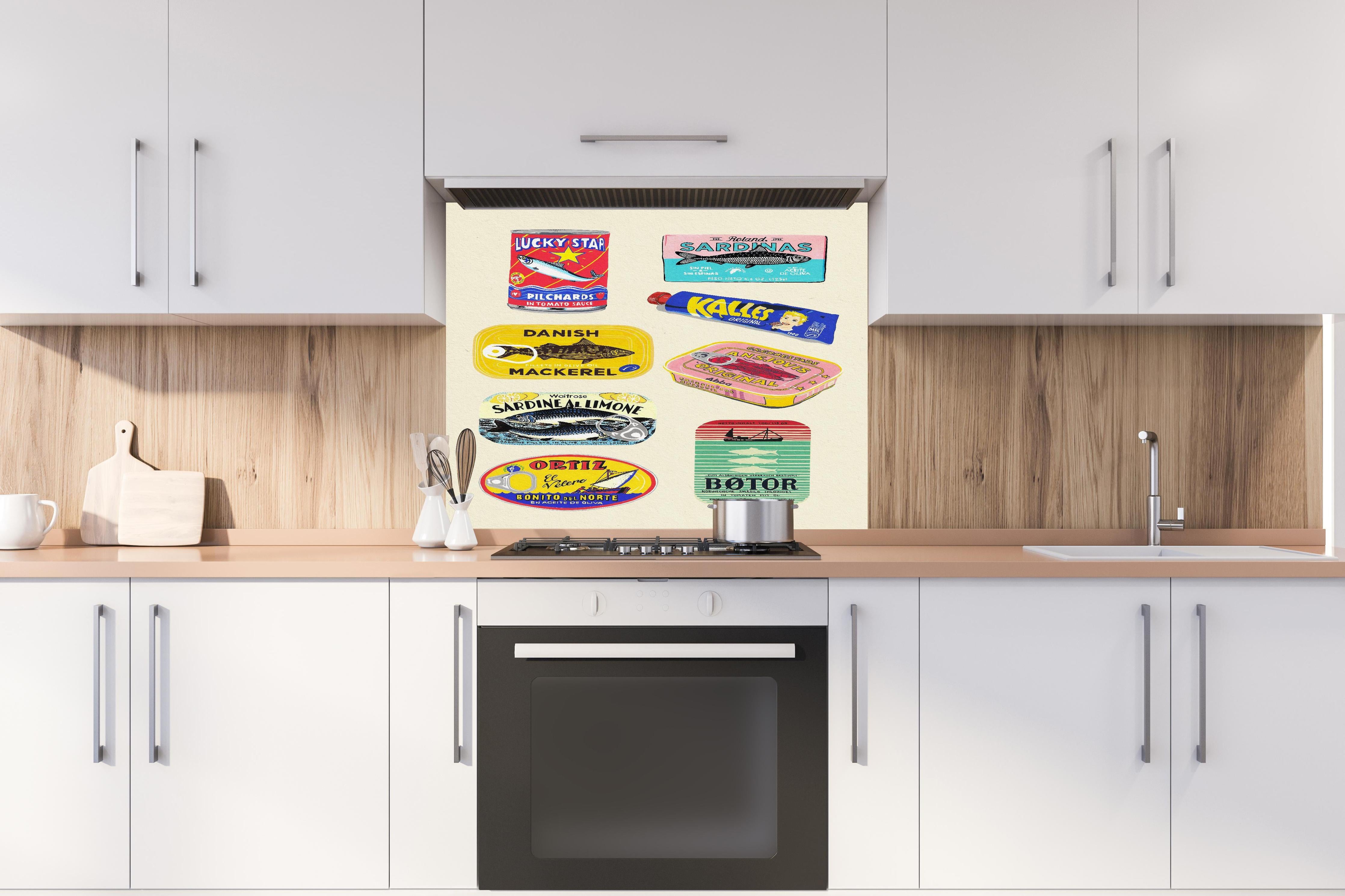 Spritzschutz - Verschiedenste Dosenfische hinter einem Cerankochfeld zwischen Holz-Kochutensilien