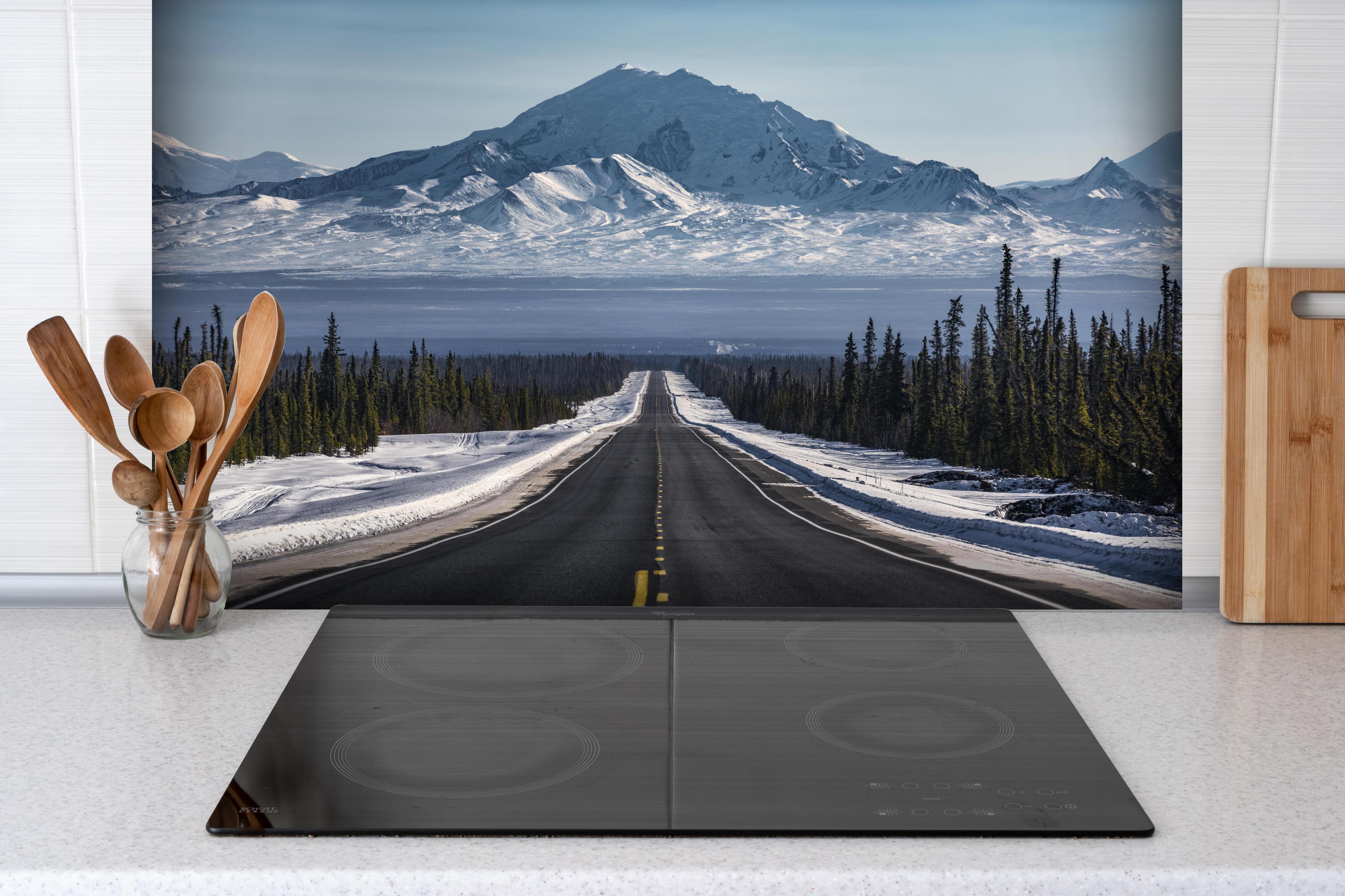 Spritzschutz - Verschneite Alpenstraße Alaska in Winterlandschaft hinter einem Cerankochfeld zwischen Holz-Kochutensilien