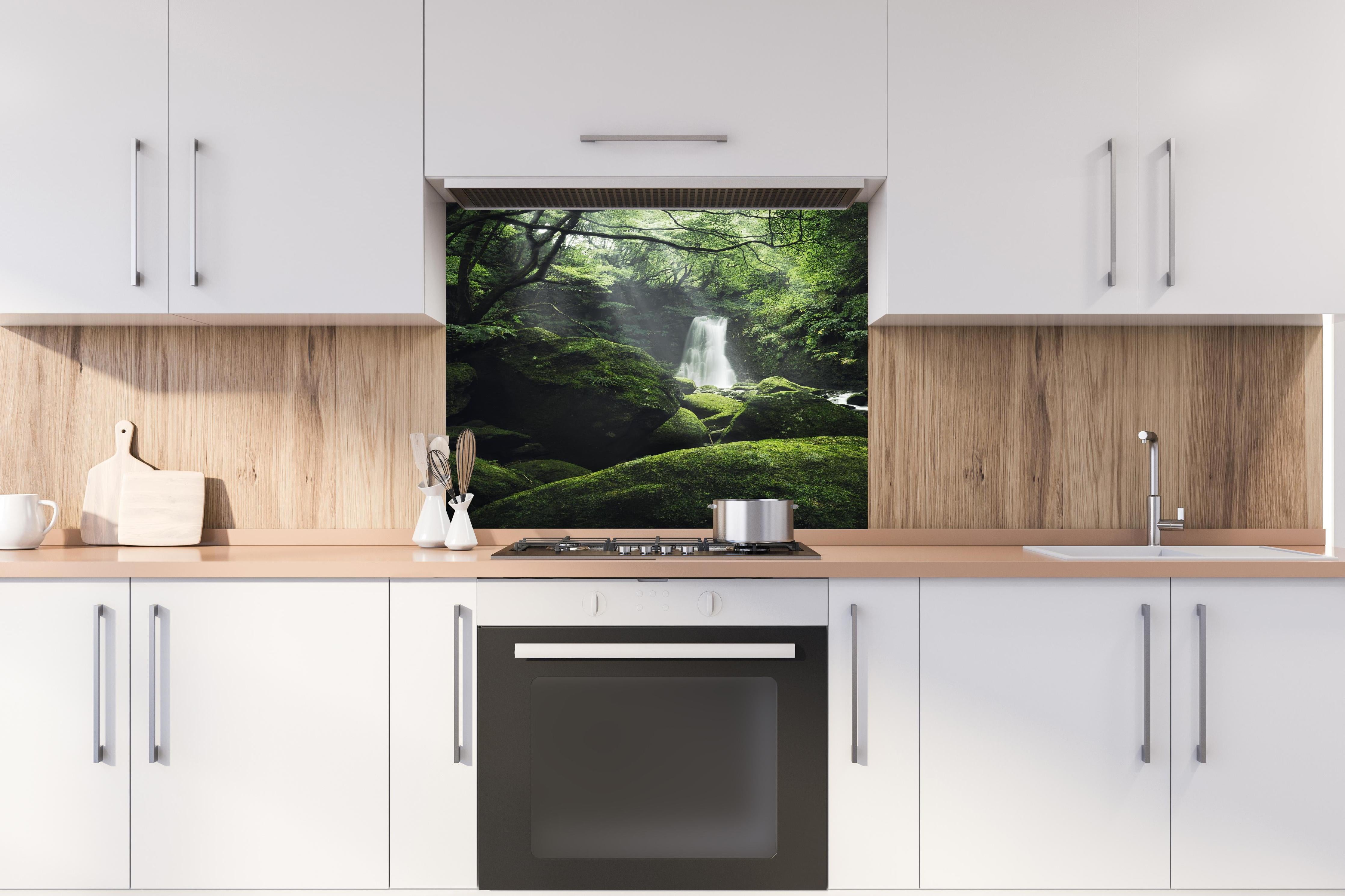 Spritzschutz - Verträumter Wasserfall im grünen Urwald hinter einem Cerankochfeld zwischen Holz-Kochutensilien