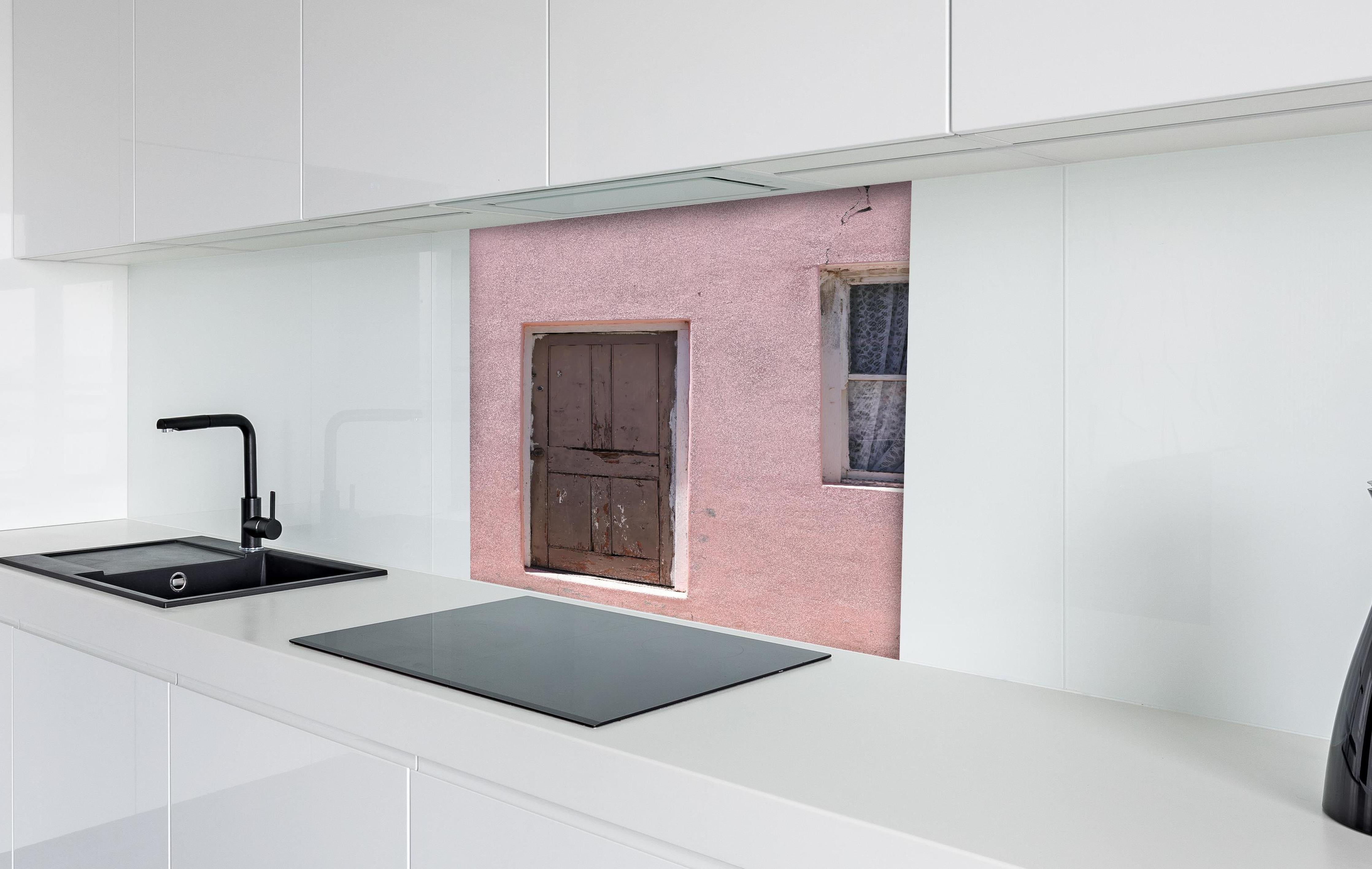 Spritzschutz - Verwitterte Holztür an rosa Bauernhaus hinter einem Cerankochfeld zwischen Holz-Kochutensilien