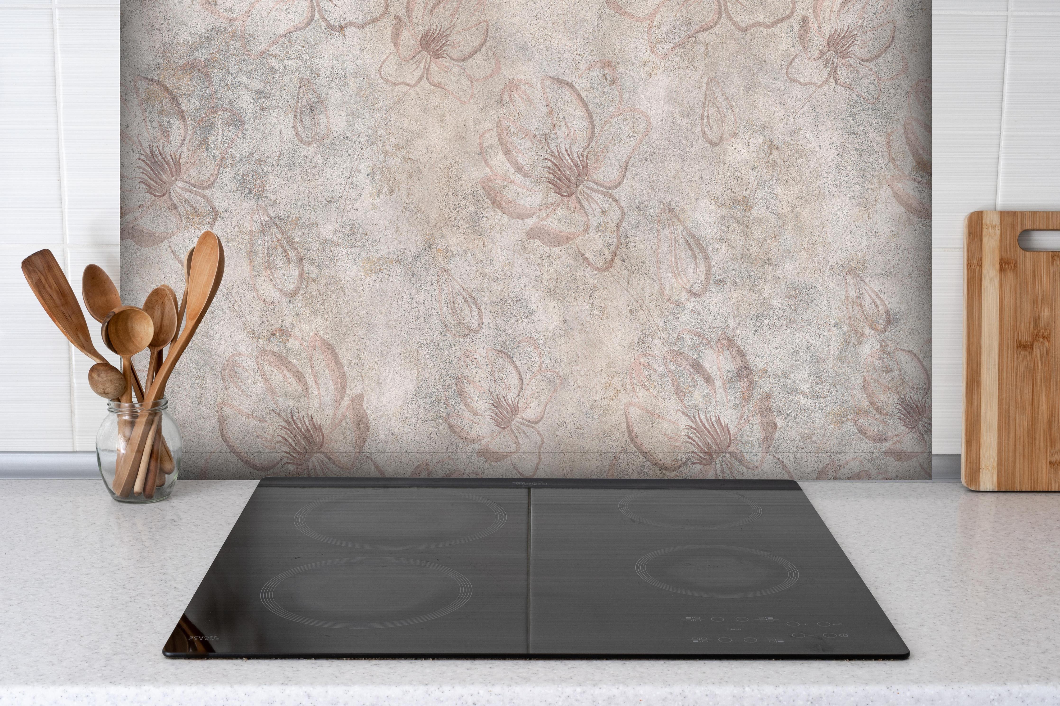 Spritzschutz - Verwitterte blumenförmige Tapete hinter einem Cerankochfeld zwischen Holz-Kochutensilien