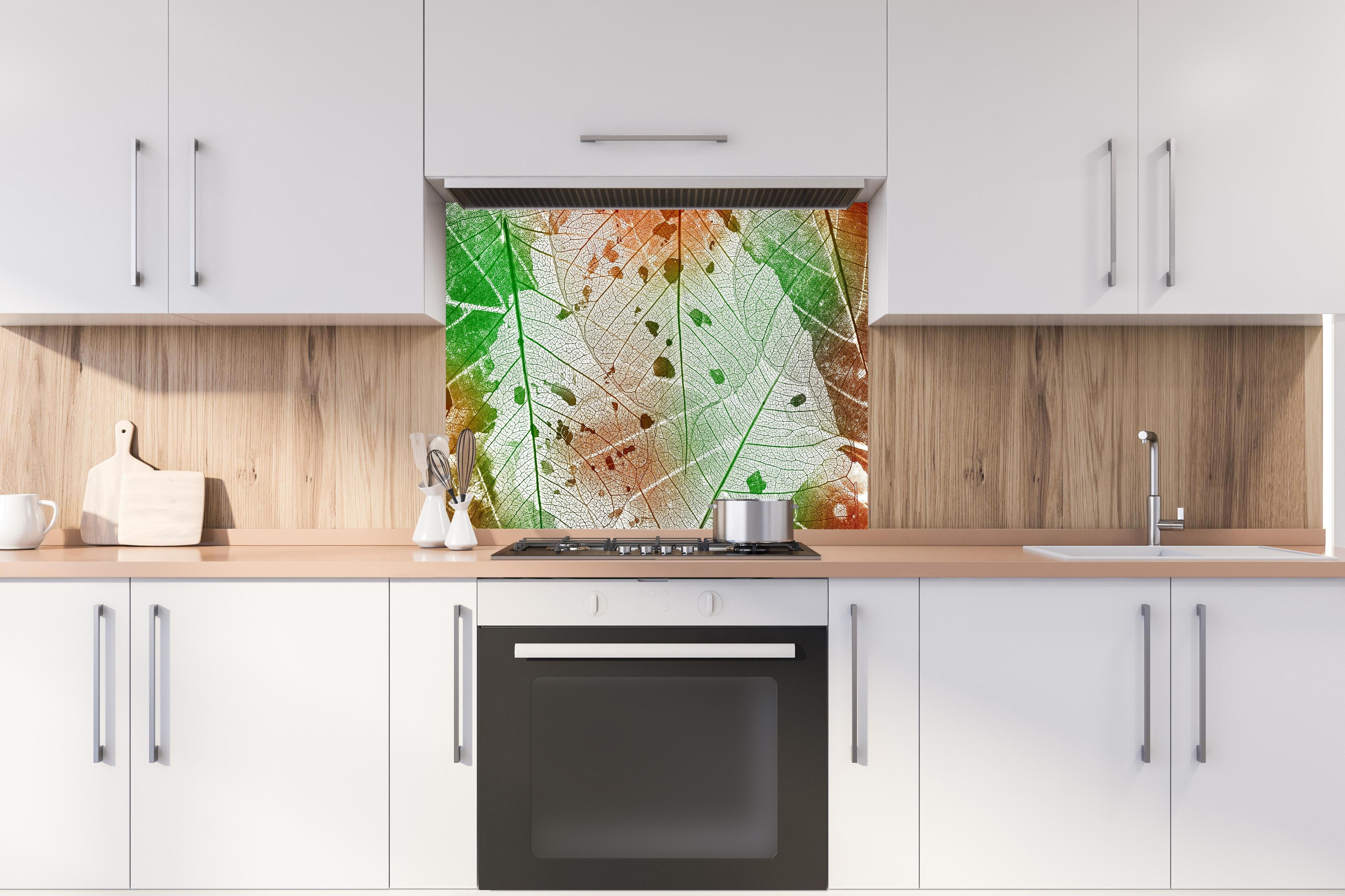 Spritzschutz - Vielfarbige Blattstruktur Detailansicht hinter einem Cerankochfeld zwischen Holz-Kochutensilien