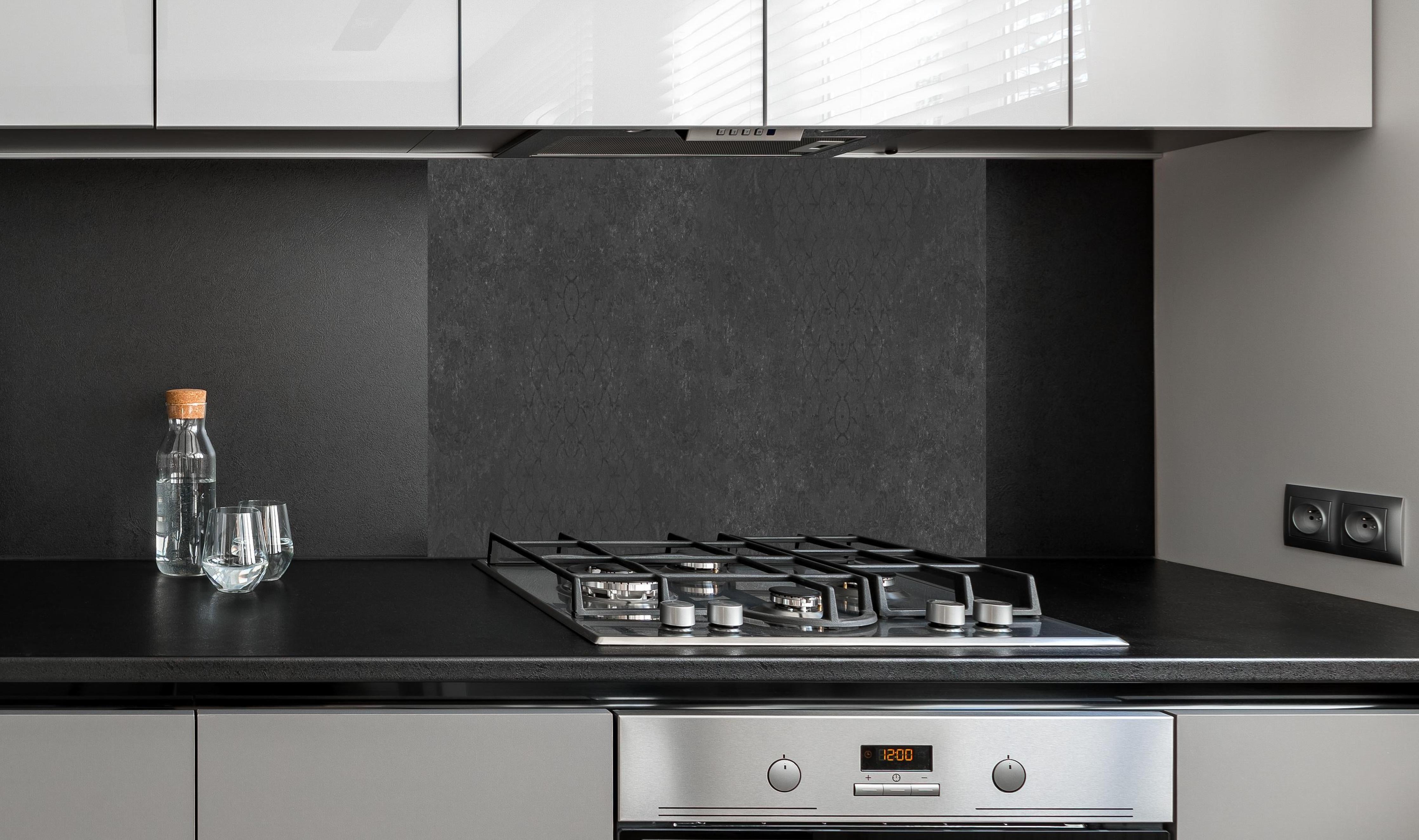 Spritzschutz - Vintage Anthrazit Betonfließen Wandbanner hinter einem Cerankochfeld zwischen Holz-Kochutensilien