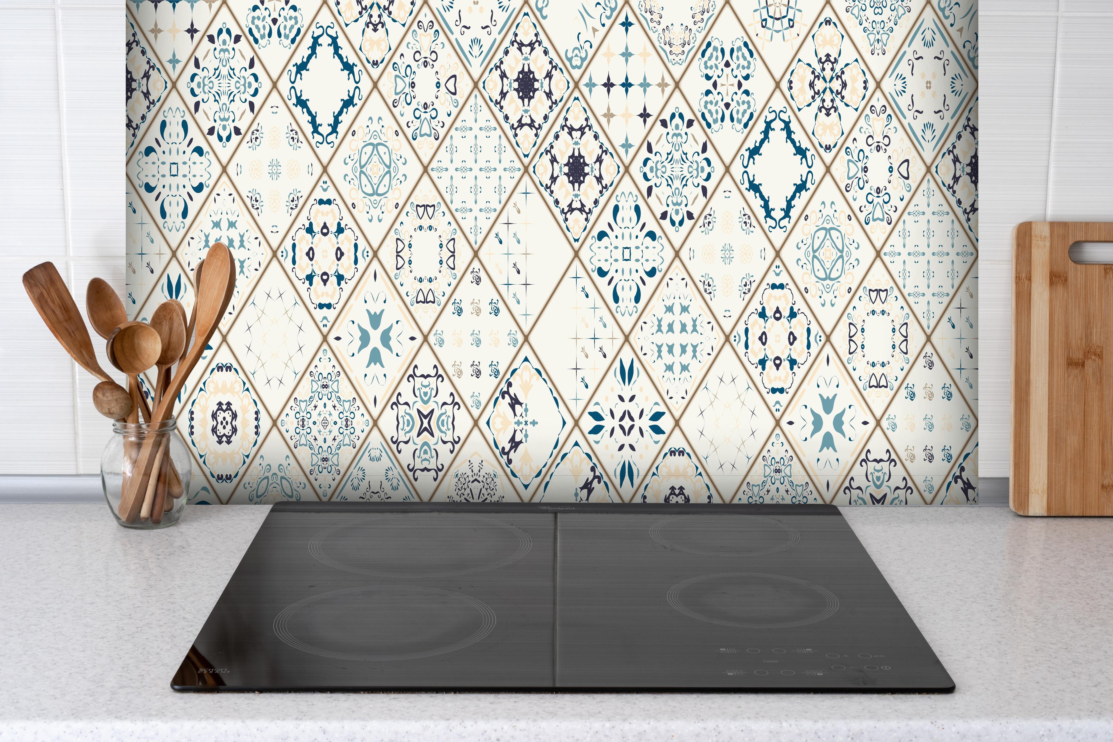 Spritzschutz - Vintage Fliesenmuster in Blau und Beige hinter einem Cerankochfeld zwischen Holz-Kochutensilien