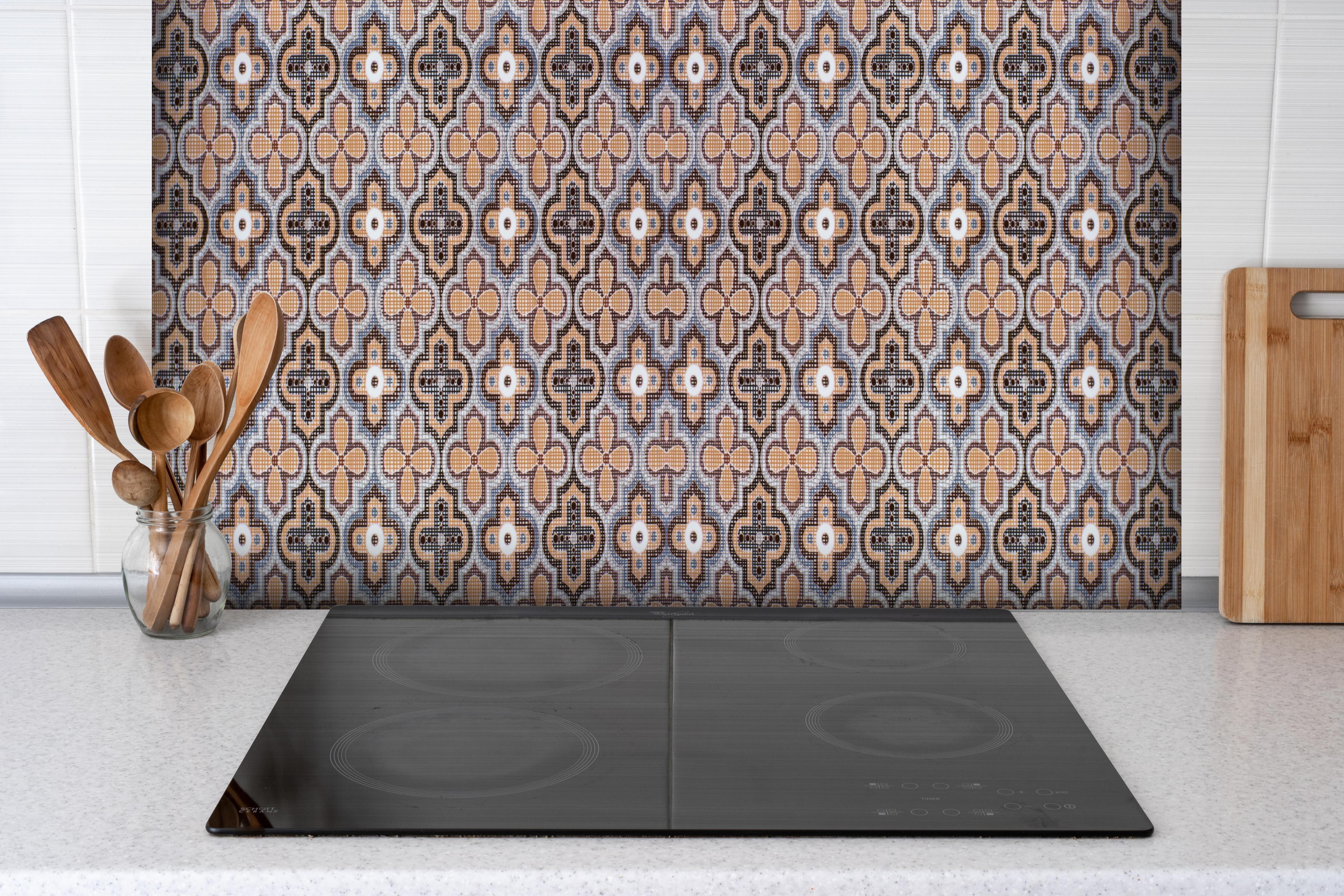 Spritzschutz - Vintage Muster in Erdtönen hinter einem Cerankochfeld zwischen Holz-Kochutensilien