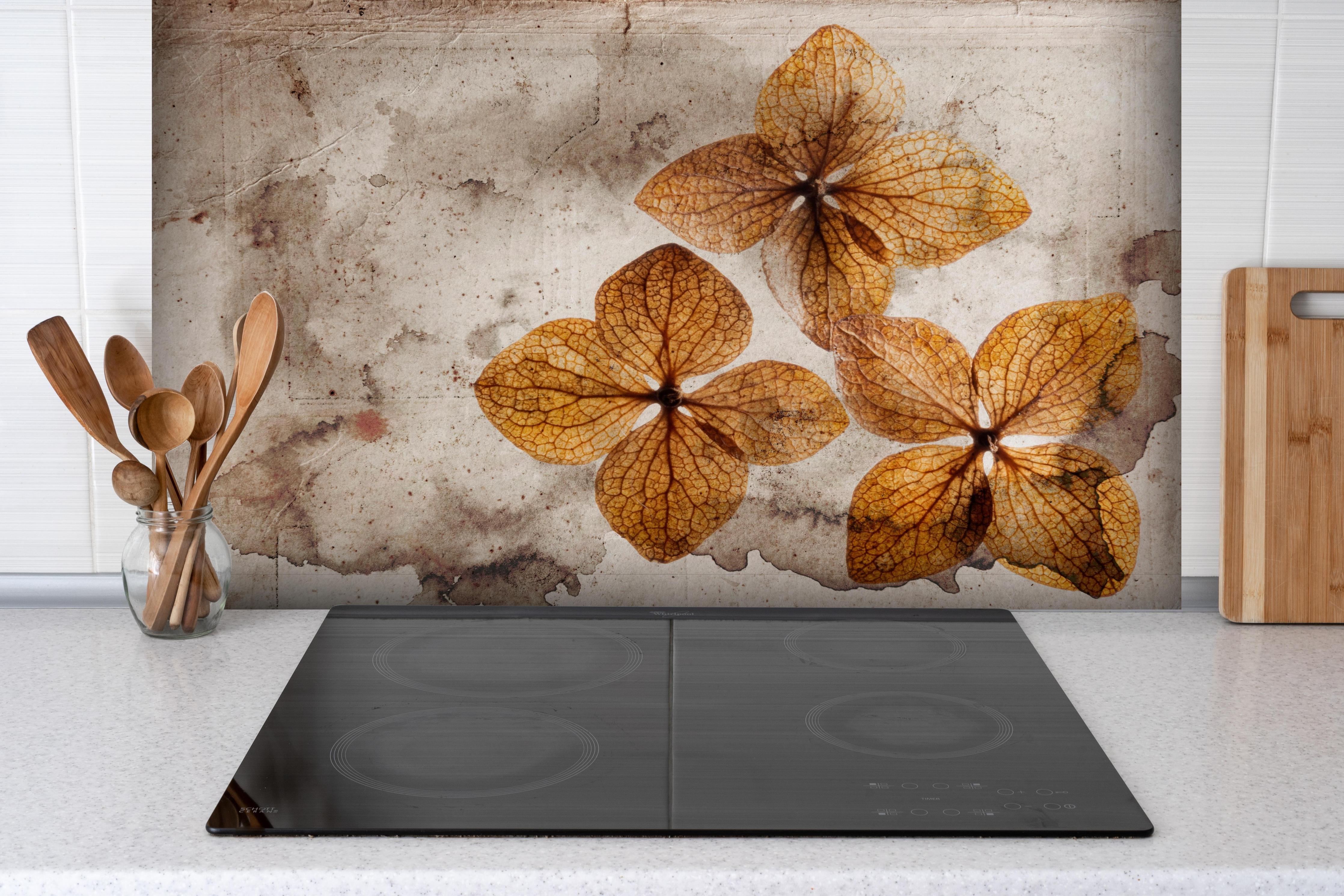 Spritzschutz - Vintage Trockene Hortensien auf Papier hinter einem Cerankochfeld zwischen Holz-Kochutensilien