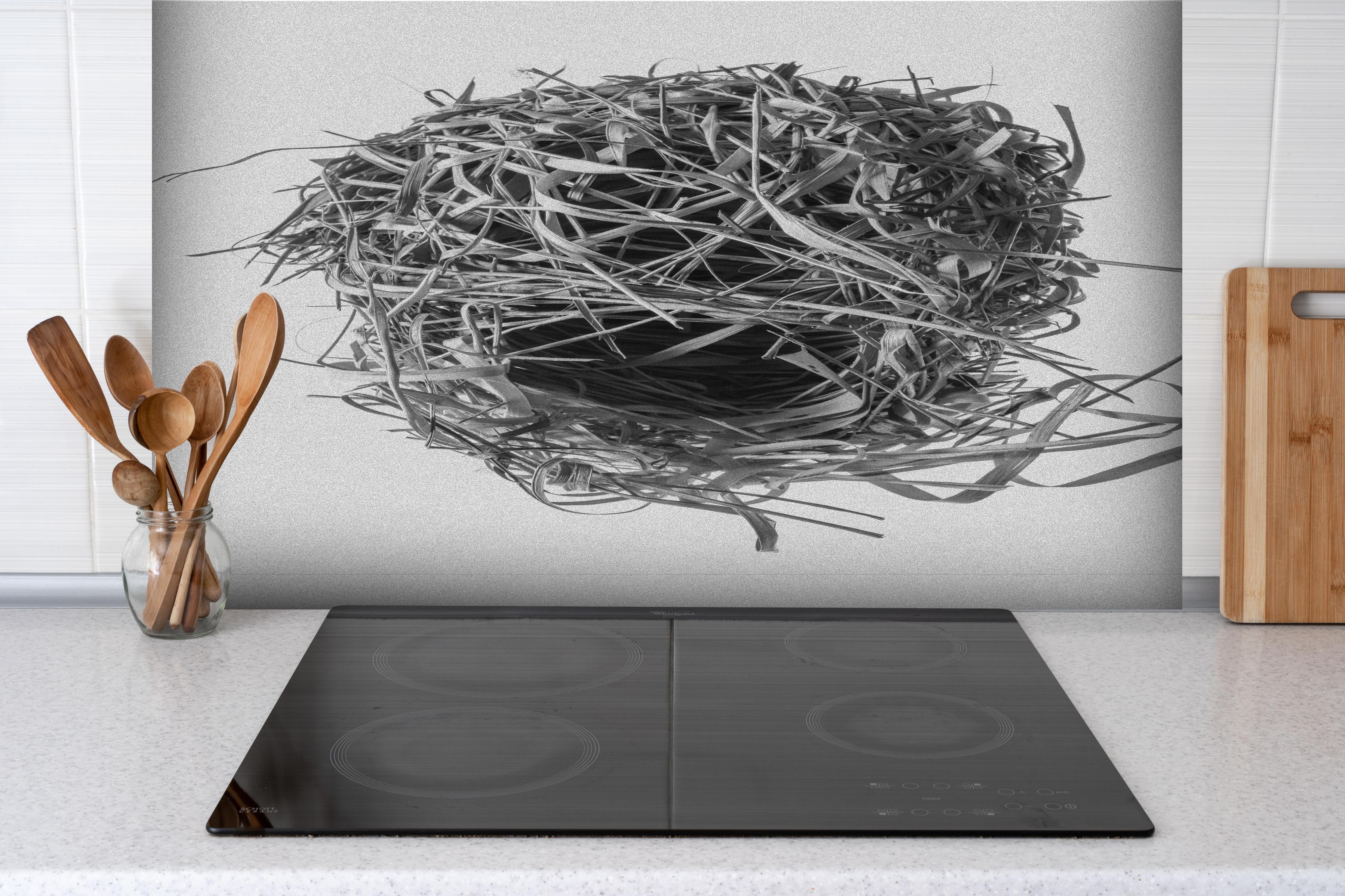 Spritzschutz - Vogelnest - schwarz-weiß hinter einem Cerankochfeld zwischen Holz-Kochutensilien