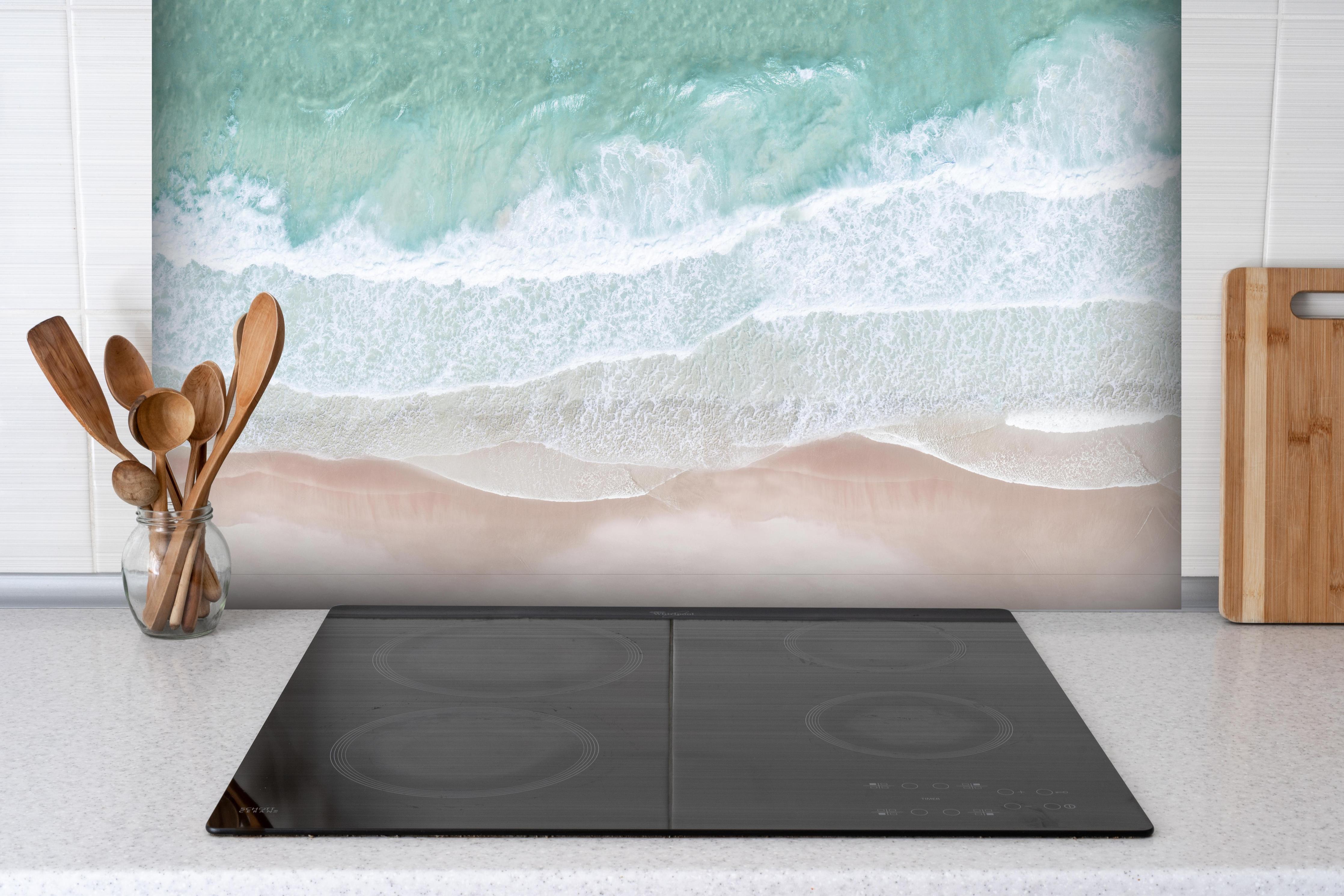 Spritzschutz - Vogelperspektive - Ozean an der Küste hinter einem Cerankochfeld zwischen Holz-Kochutensilien