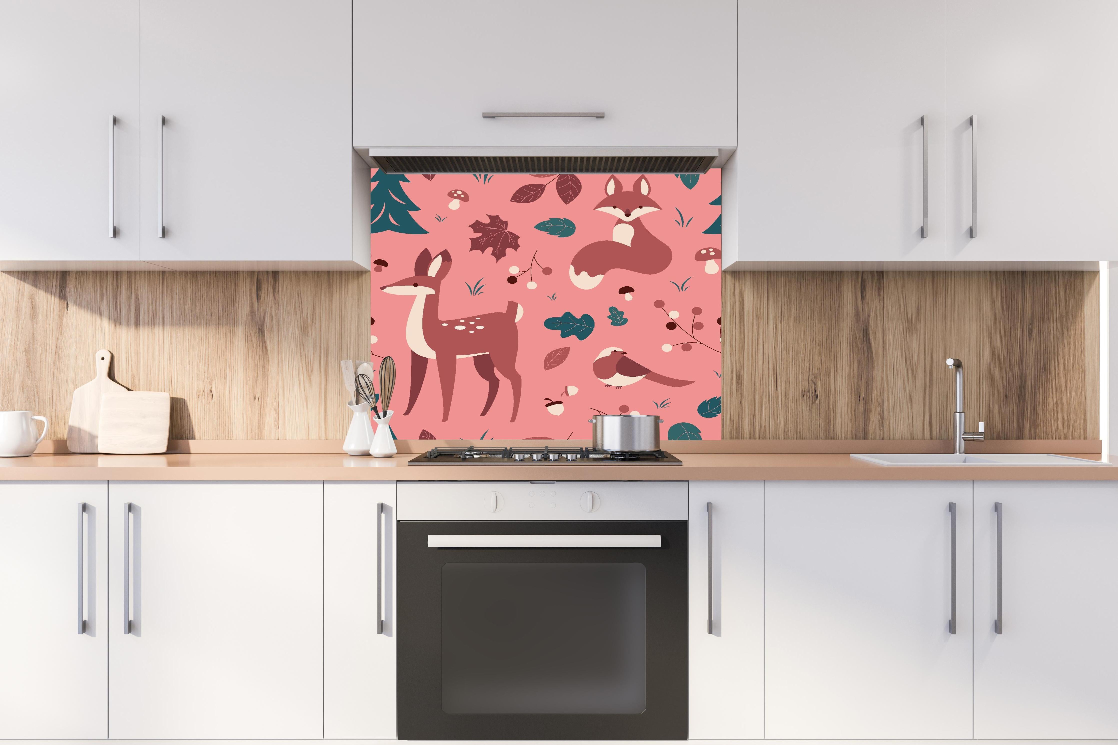 Spritzschutz - Waldtiermuster mit rosa Hintergrundillustration hinter einem Cerankochfeld zwischen Holz-Kochutensilien
