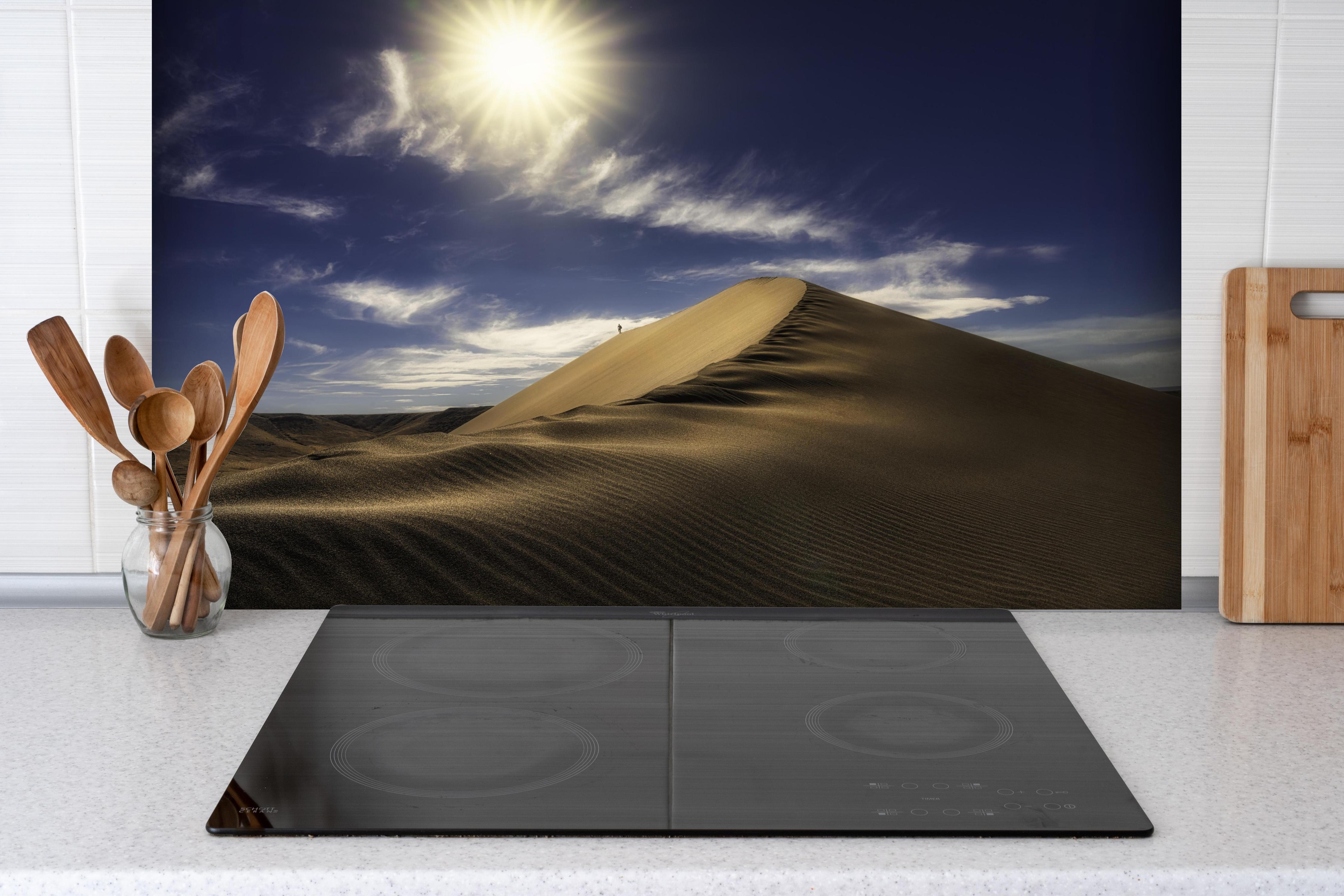 Spritzschutz - Wanderer in der Wüste hinter einem Cerankochfeld zwischen Holz-Kochutensilien