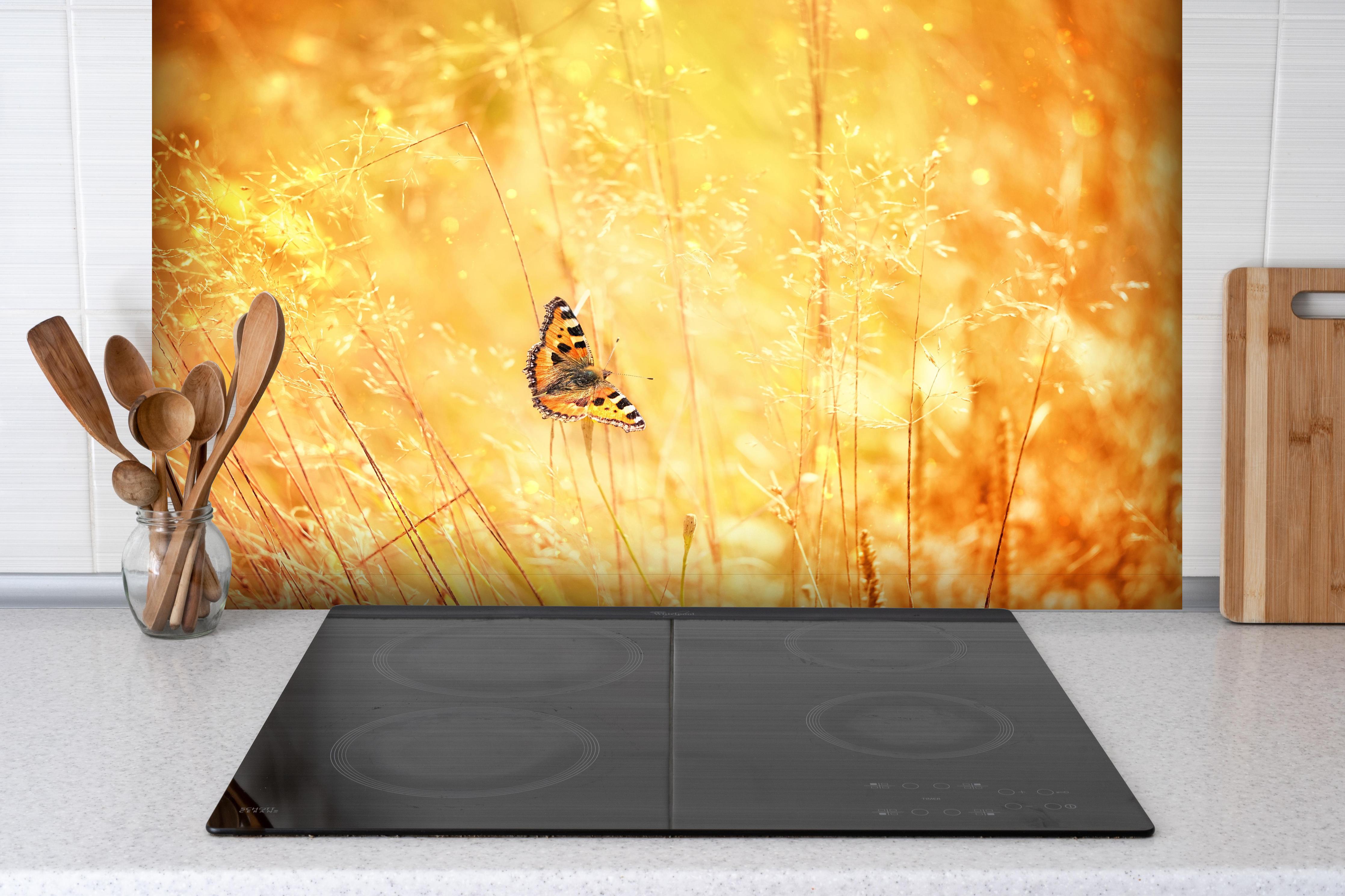 Spritzschutz - Warme Goldtöne im sommerlichen Feldmotiv hinter einem Cerankochfeld zwischen Holz-Kochutensilien