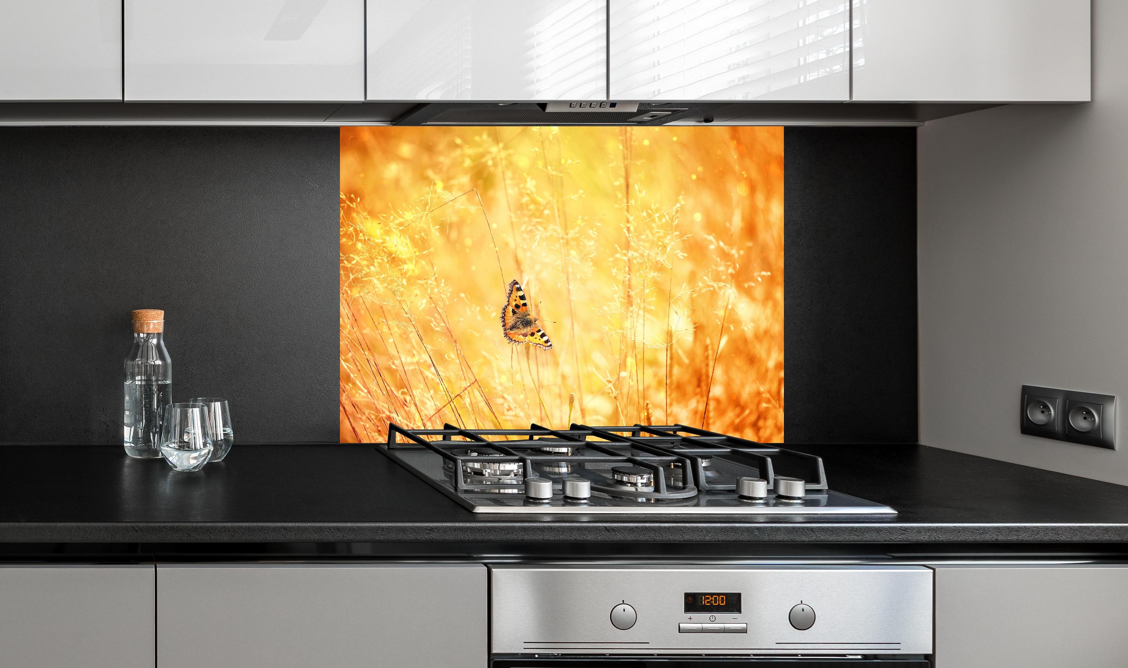 Spritzschutz - Warme Goldtöne im sommerlichen Feldmotiv hinter einem Cerankochfeld zwischen Holz-Kochutensilien