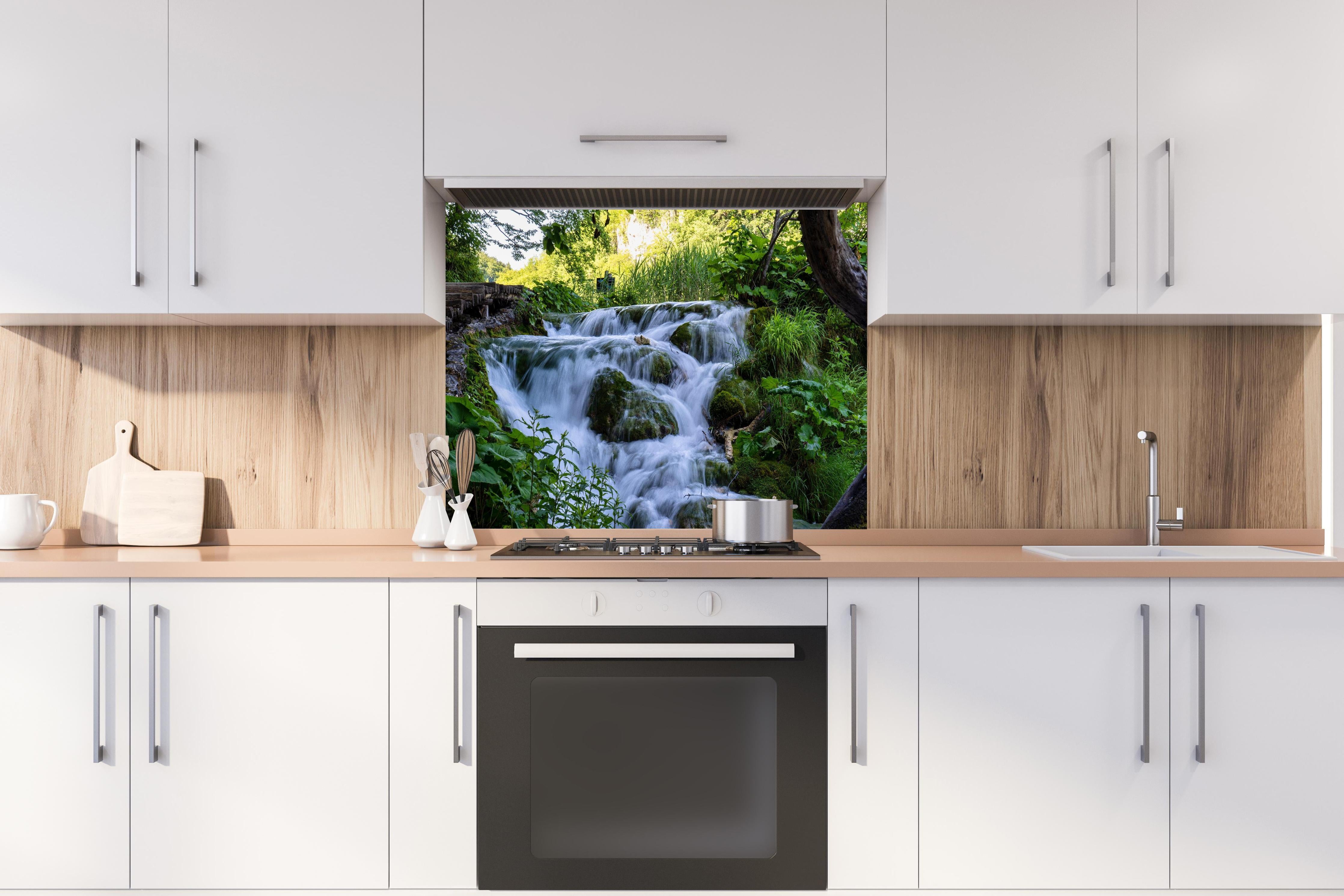 Spritzschutz - Wasserfall im Nationalpark Plitvicer Seen hinter einem Cerankochfeld zwischen Holz-Kochutensilien