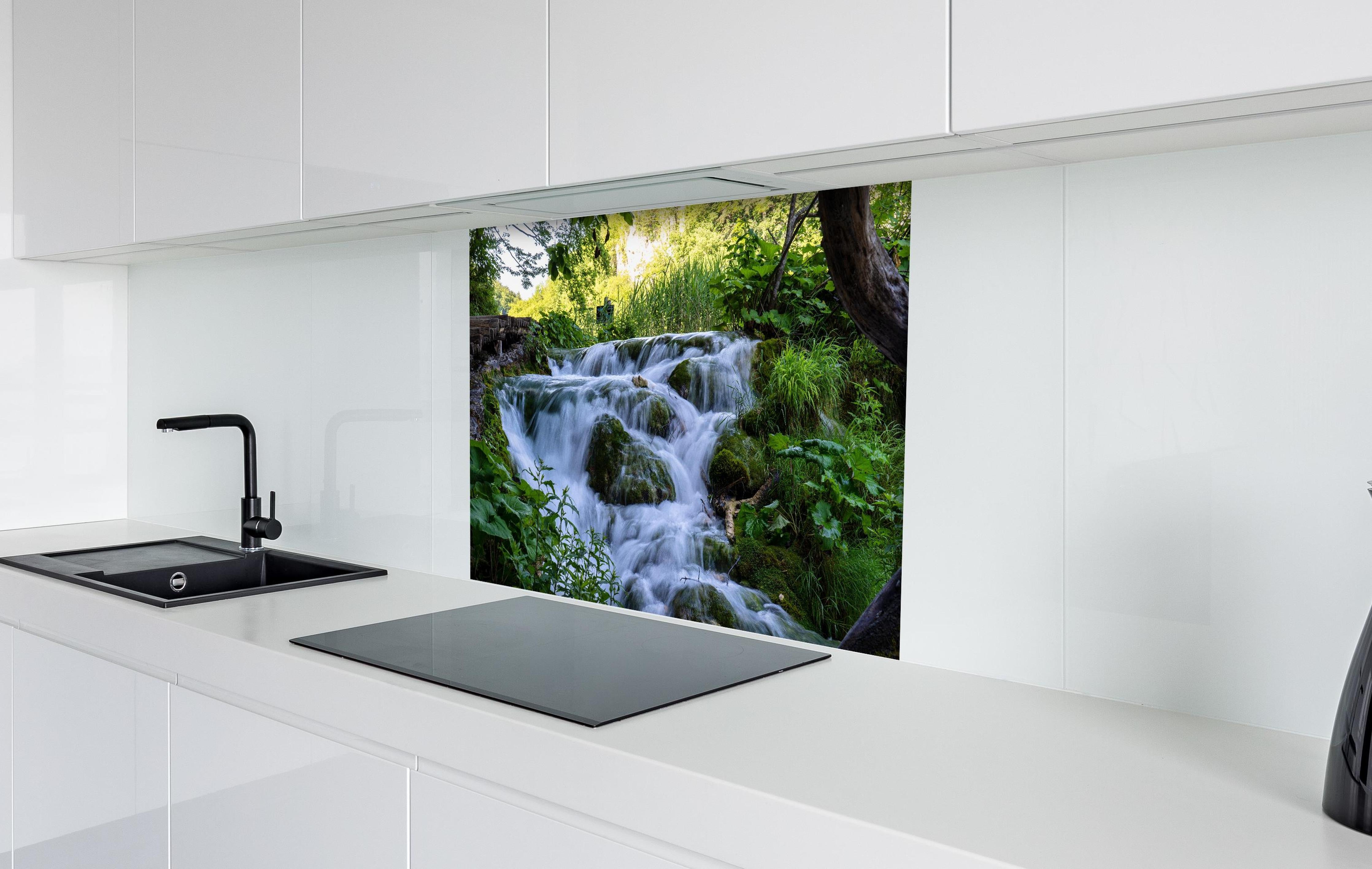 Spritzschutz - Wasserfall im Nationalpark Plitvicer Seen hinter einem Cerankochfeld zwischen Holz-Kochutensilien