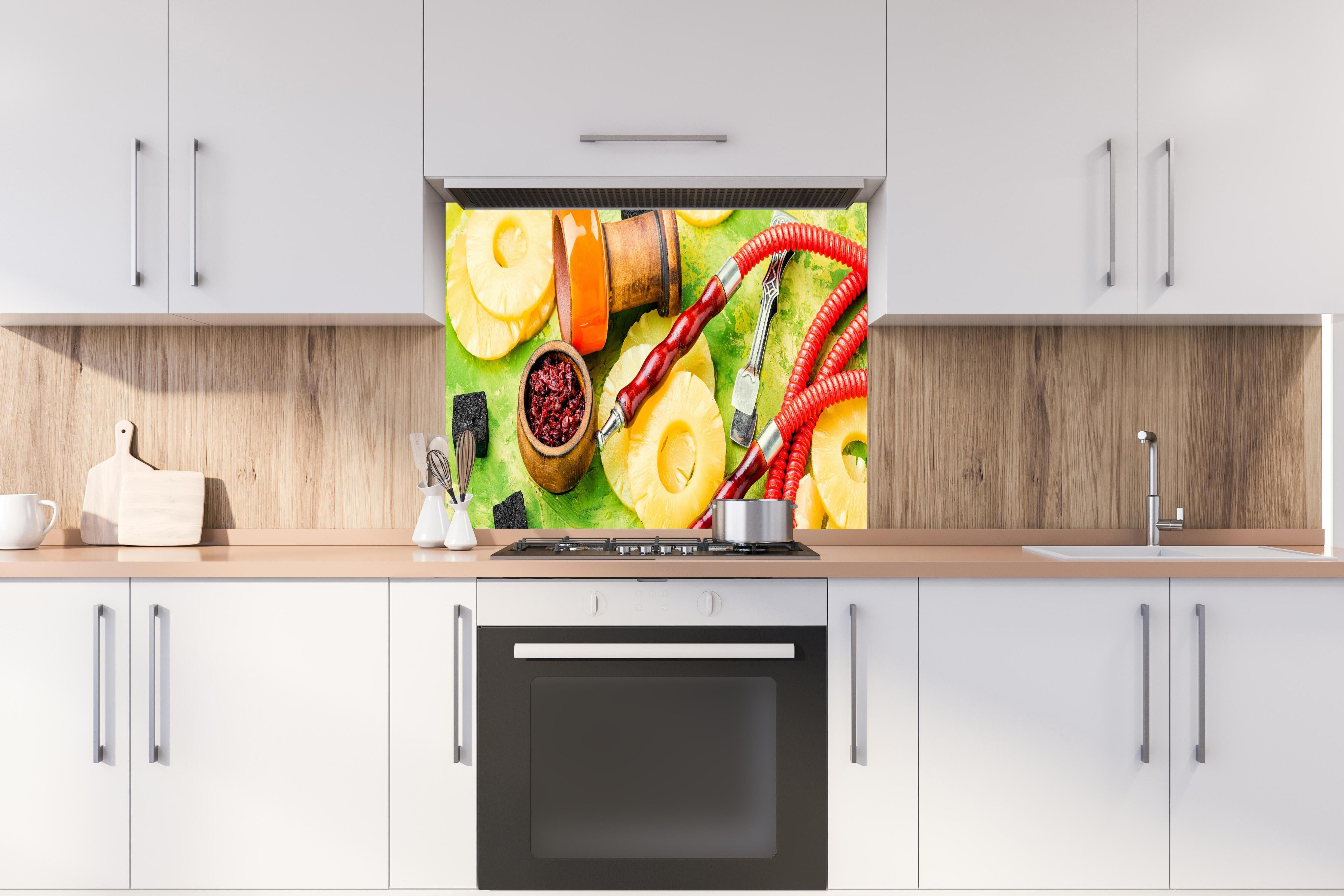 Spritzschutz - Wasserpfeife mit Ananas-Aroma. hinter einem Cerankochfeld zwischen Holz-Kochutensilien