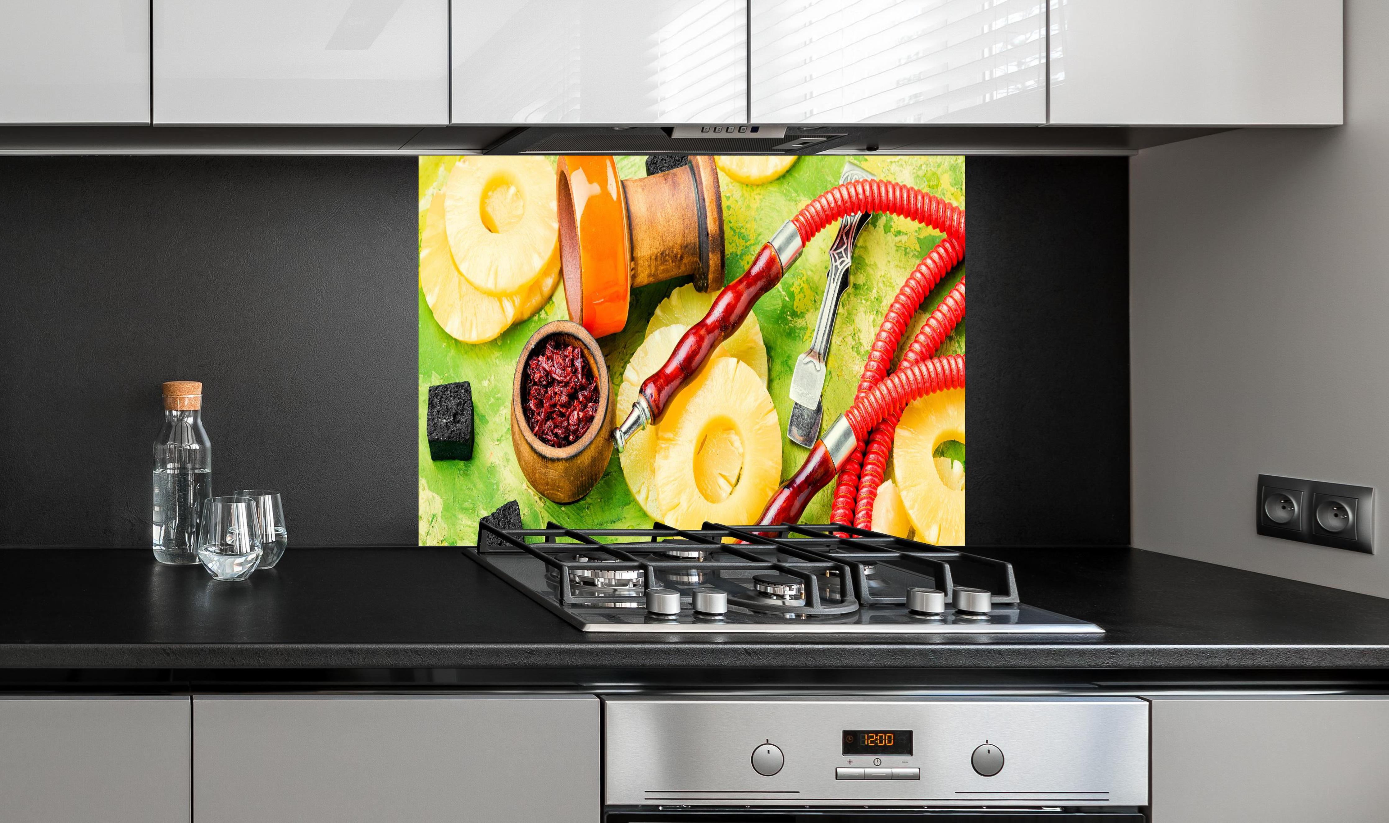 Spritzschutz - Wasserpfeife mit Ananas-Aroma. hinter einem Cerankochfeld zwischen Holz-Kochutensilien