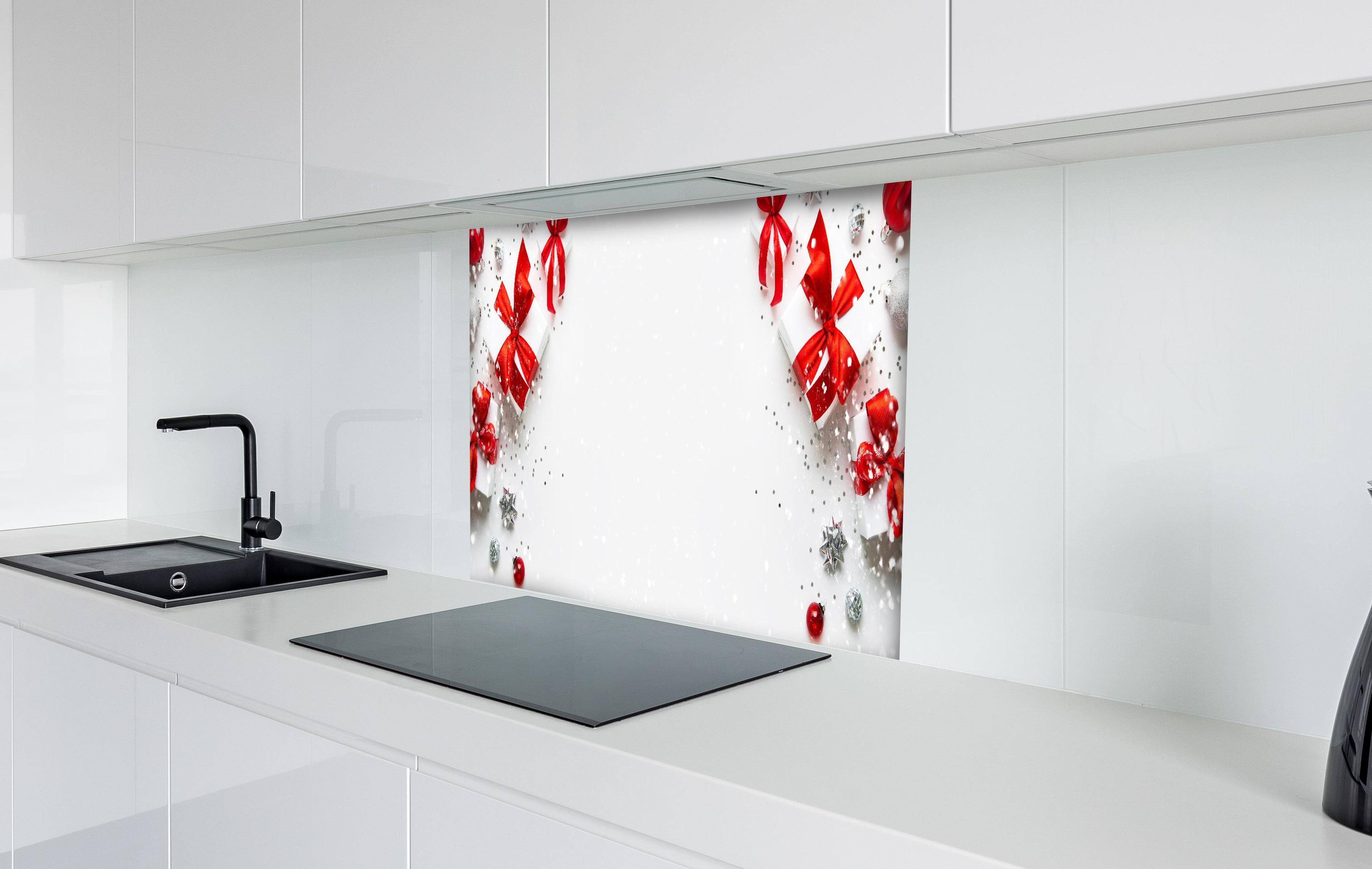 Spritzschutz - Weihnachtliche Geschenke mit Roter Schleife hinter einem Cerankochfeld zwischen Holz-Kochutensilien