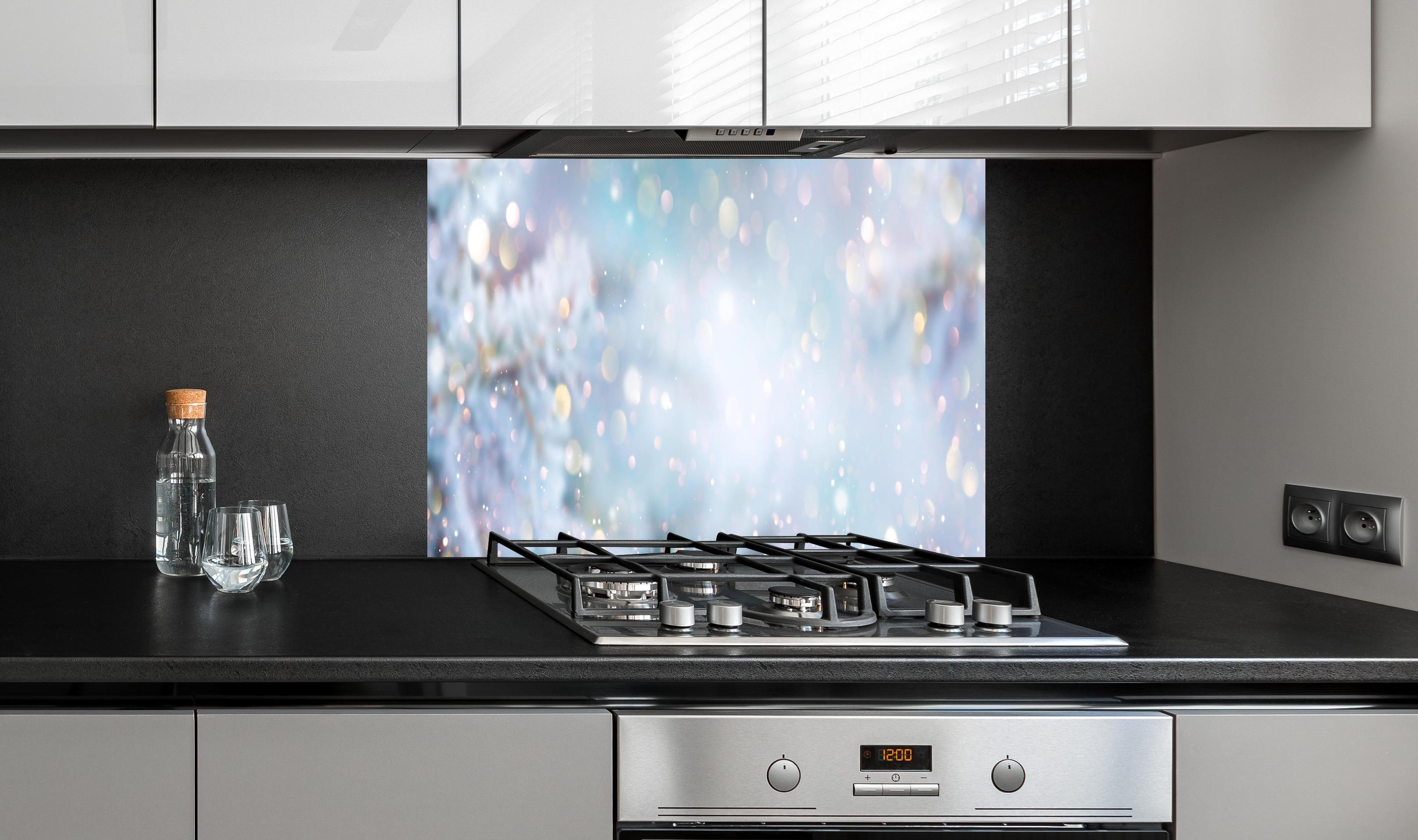 Spritzschutz - Weihnachtlicher Hintergrund mit Licht und Schnee hinter einem Cerankochfeld zwischen Holz-Kochutensilien