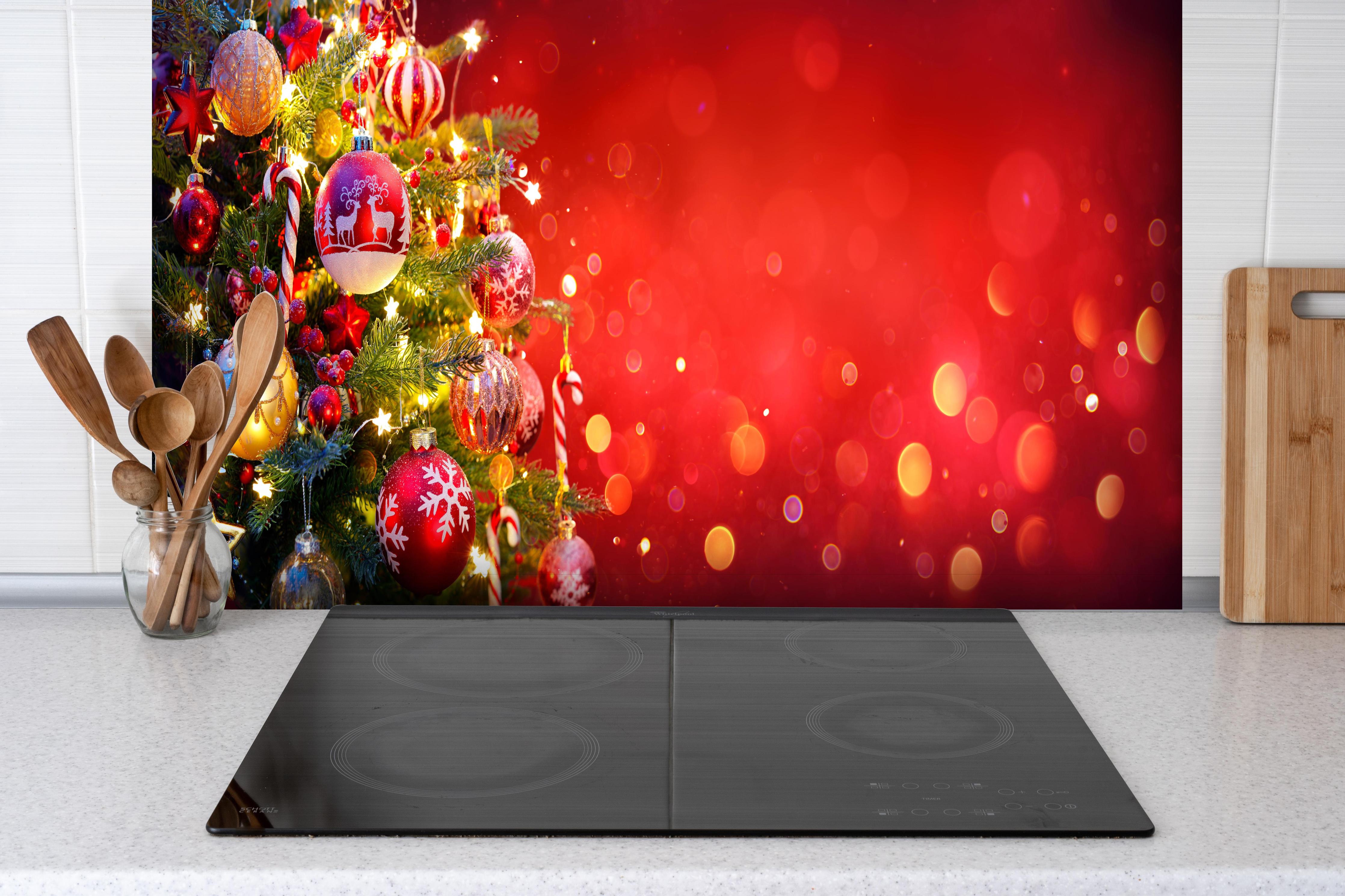 Spritzschutz - Weihnachtsbaum hinter einem Cerankochfeld zwischen Holz-Kochutensilien