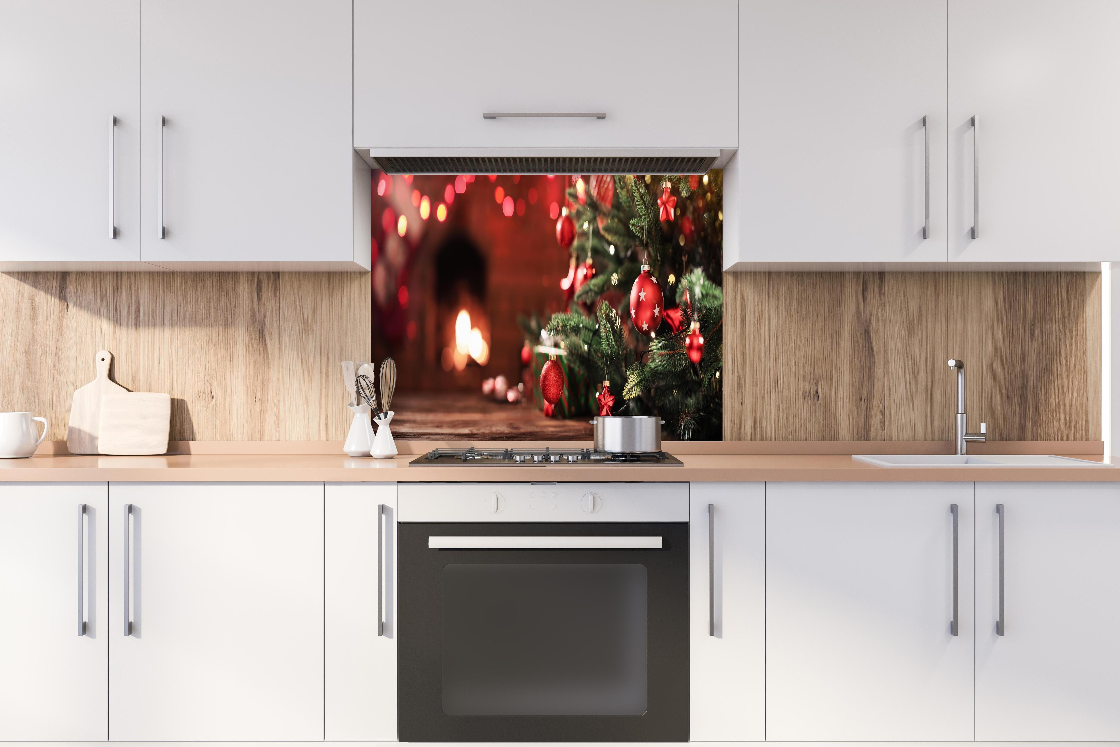 Spritzschutz - Weihnachtsbaum mit Dekorationen hinter einem Cerankochfeld zwischen Holz-Kochutensilien
