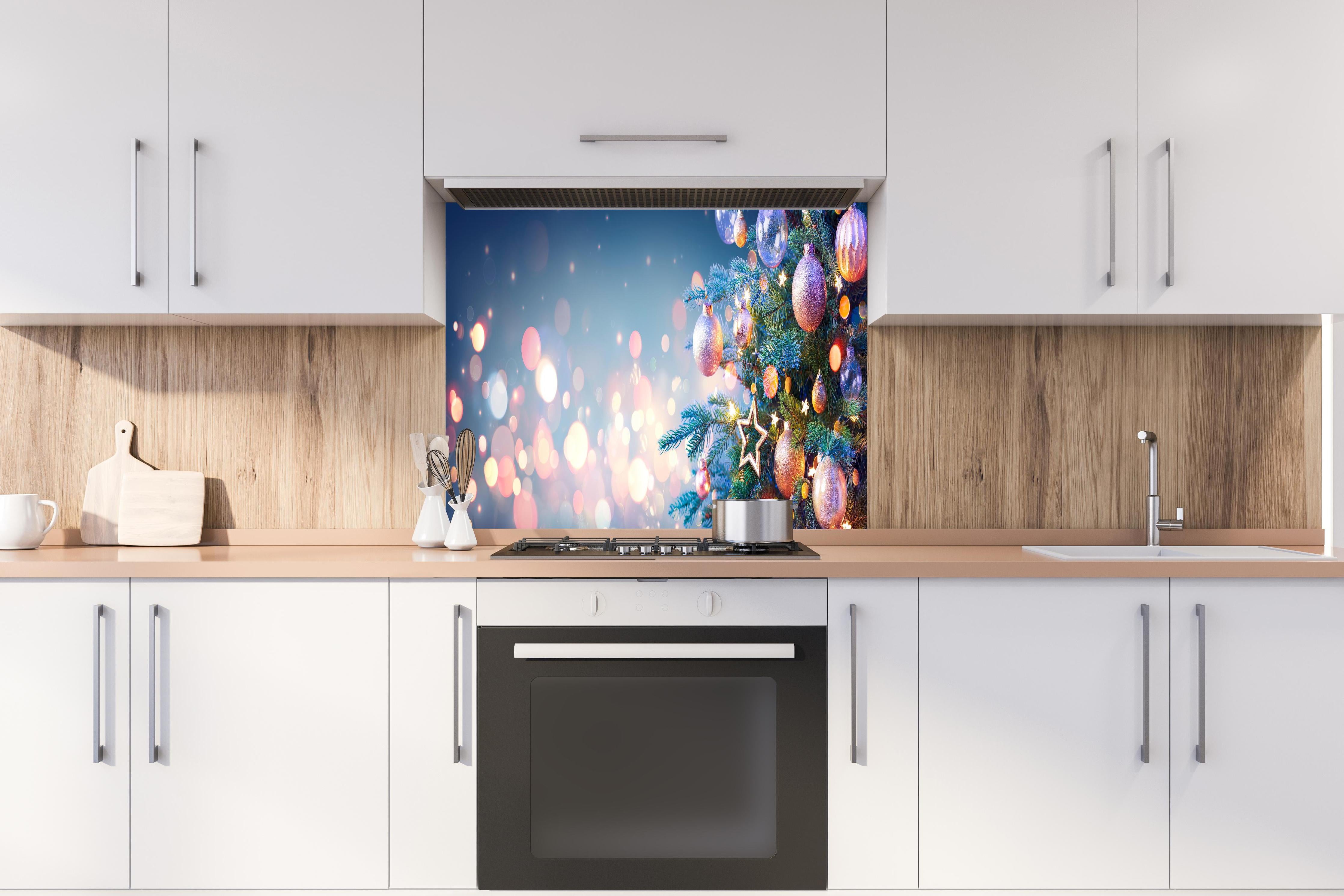 Spritzschutz - Weihnachtsbaum mit bunten Kugeln hinter einem Cerankochfeld zwischen Holz-Kochutensilien